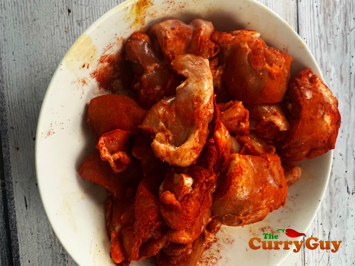 Chicken marinating in chilli powder, salt and turmeric