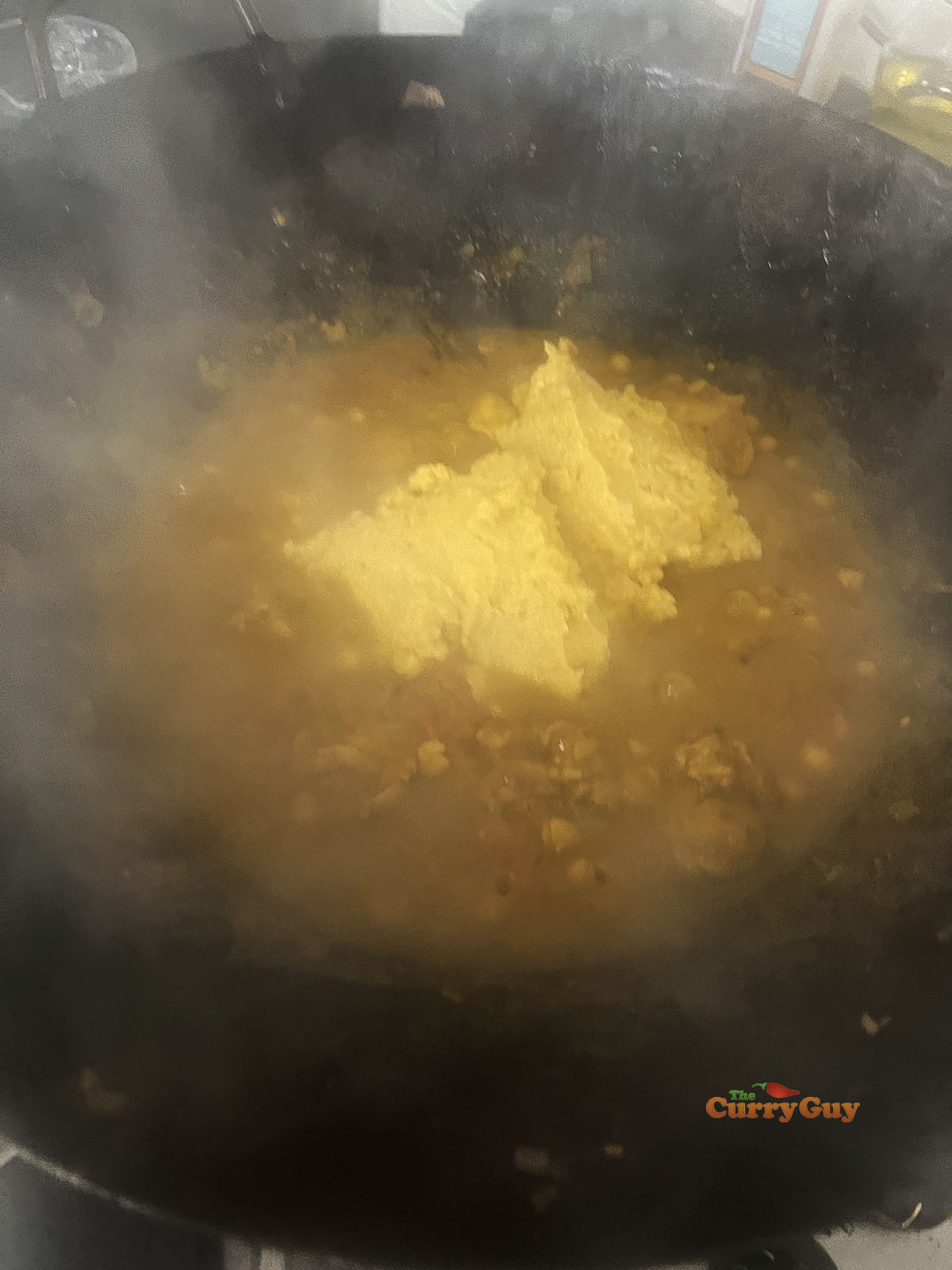 Adding the chickpea paste to the curry.