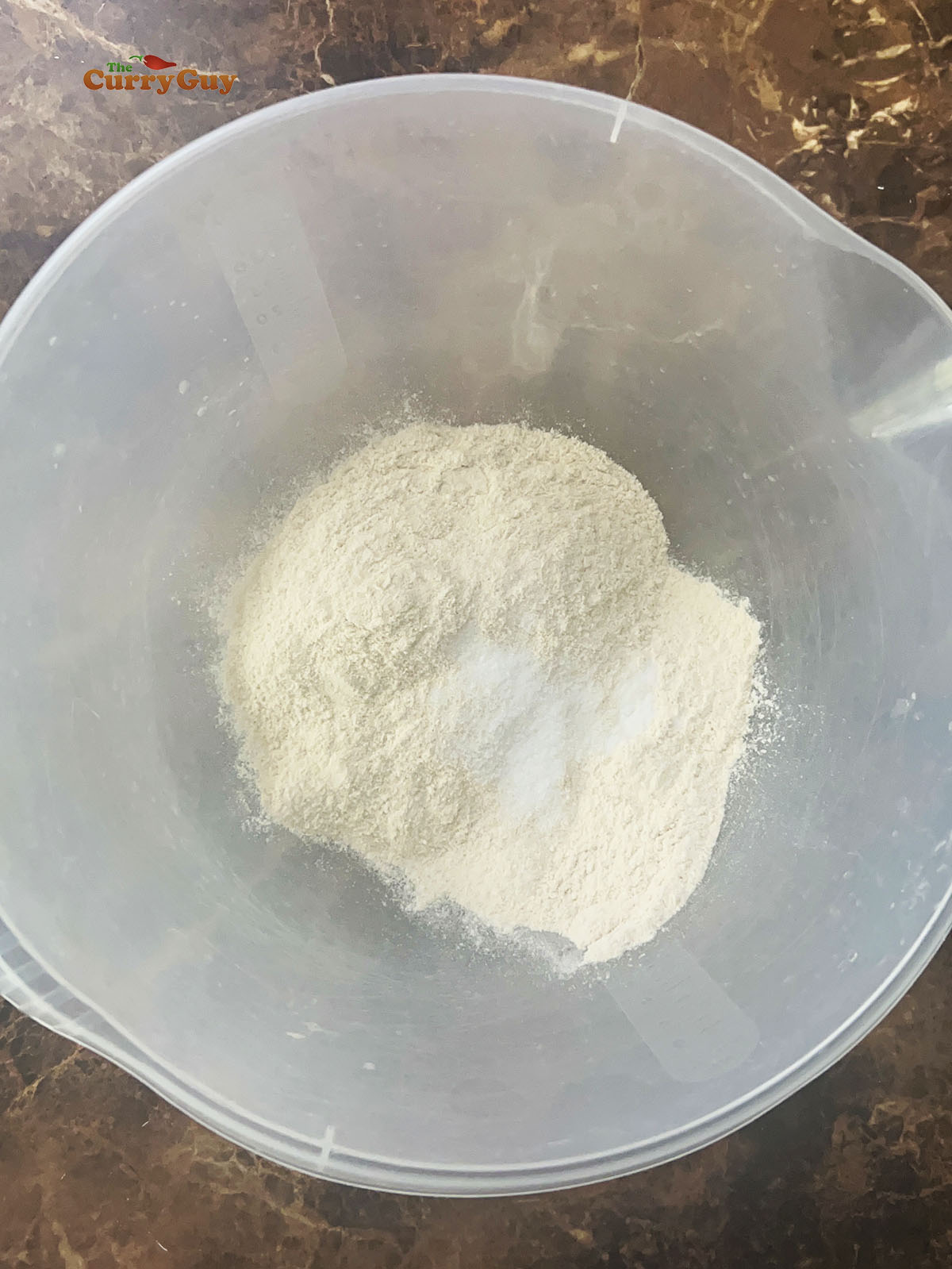 Adding the flour and salt to a mixing bowl.