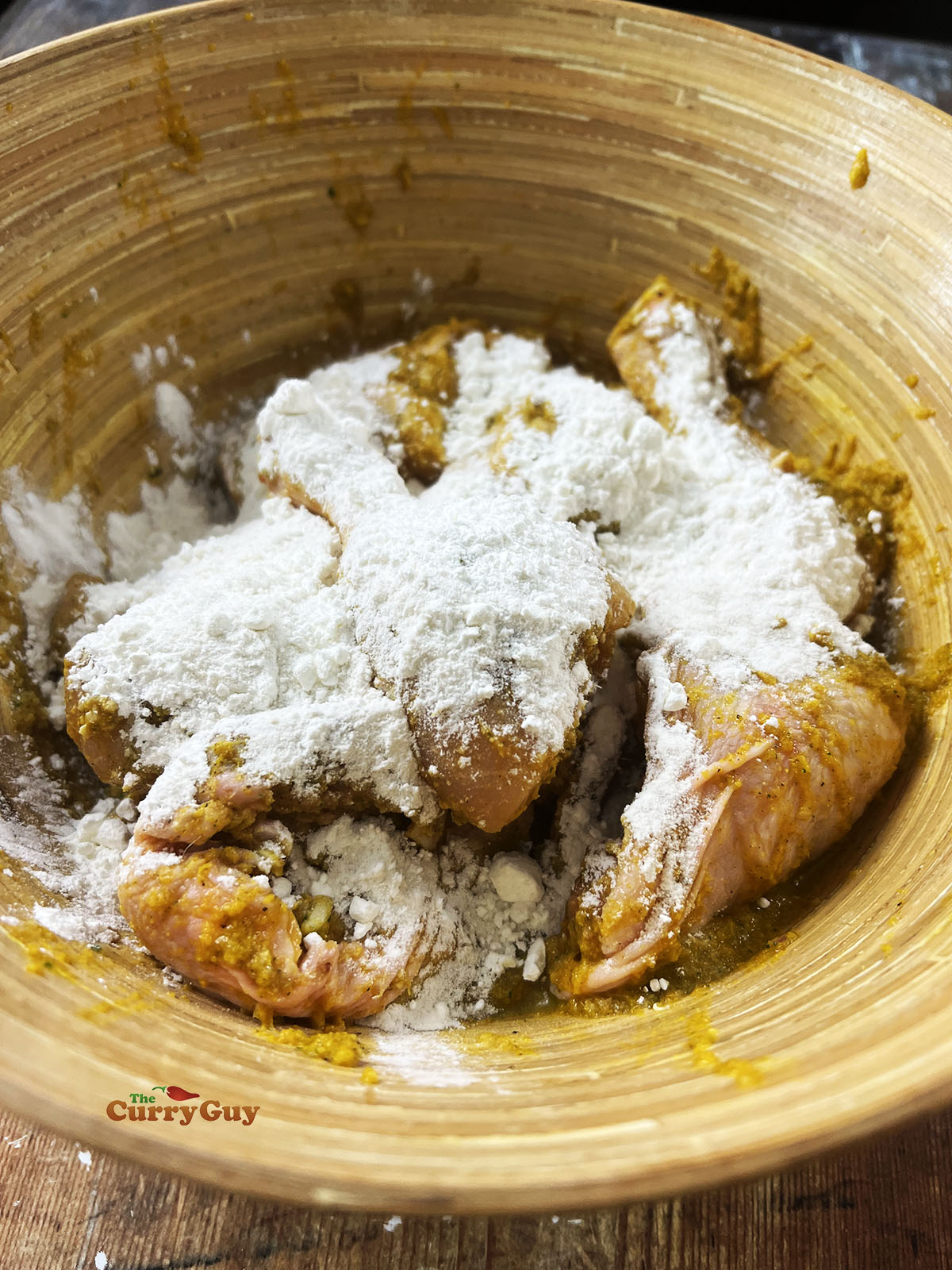 Covering the chicken with the marinade and flour.