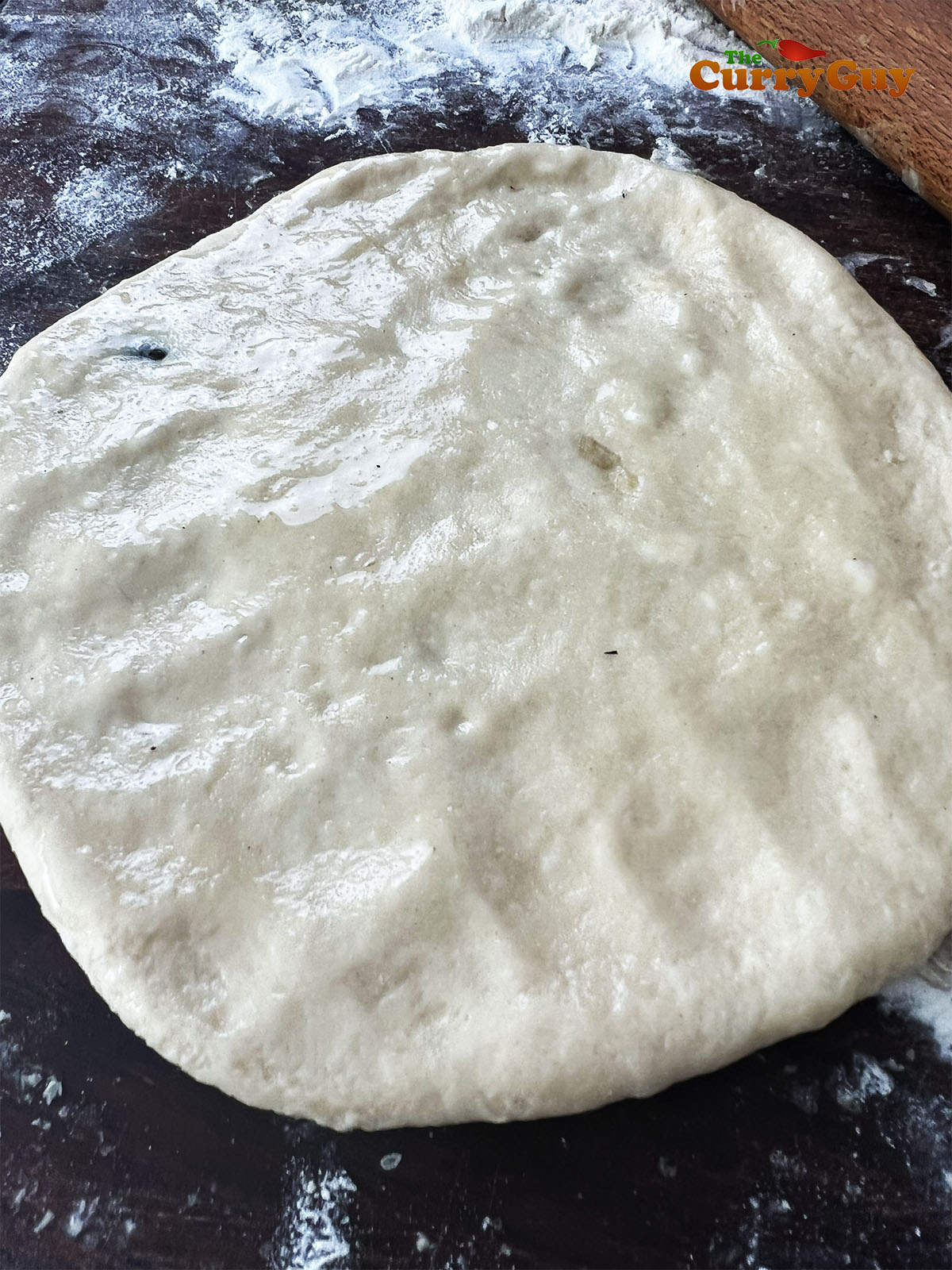 Oil being added to the rolled out dough.