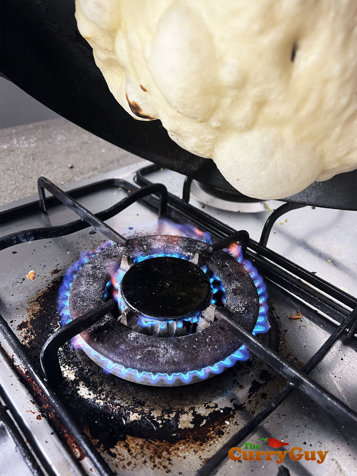 Browning the naan over the flame.