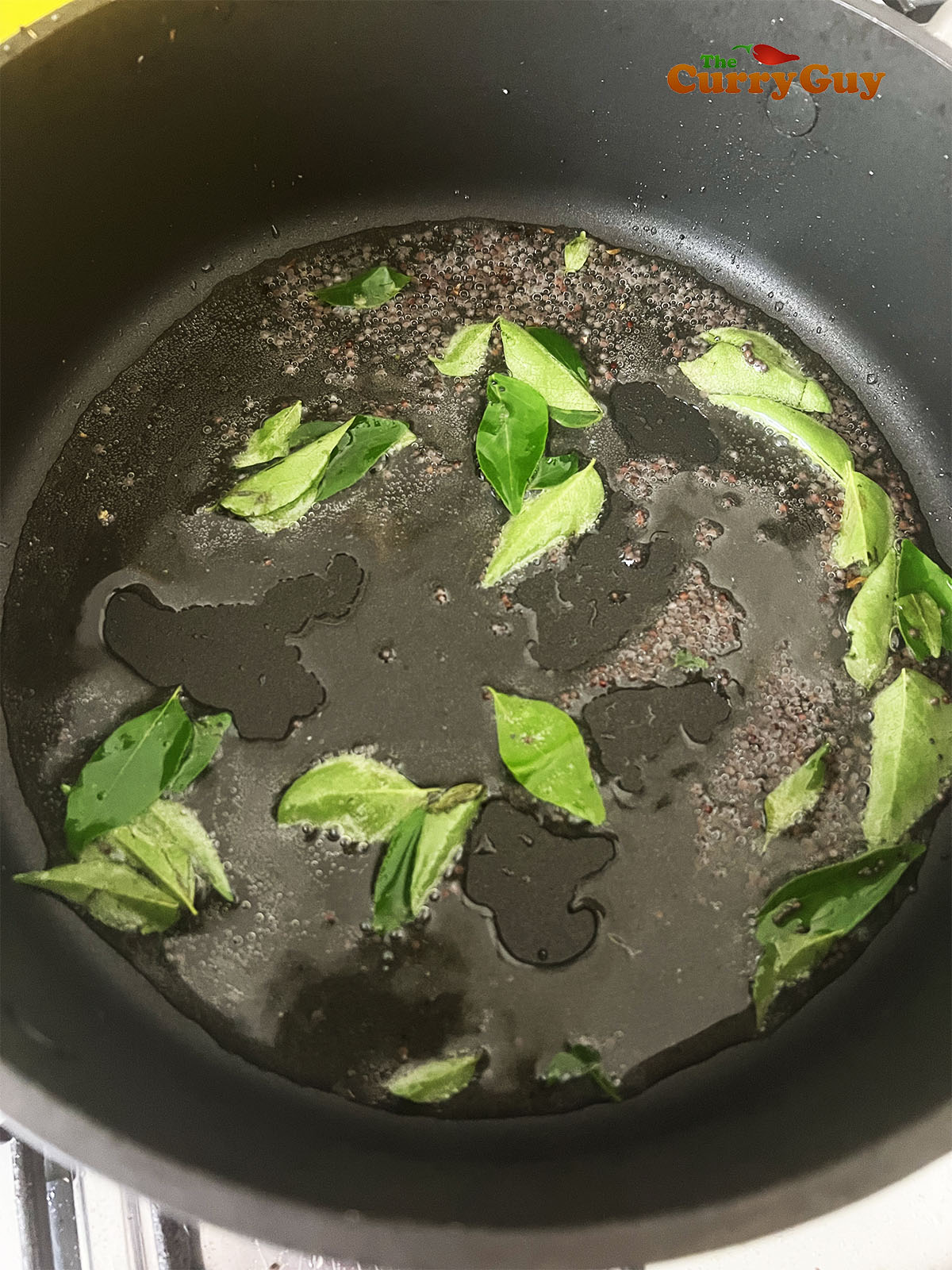 Frying the mustard seeds and curry leaves.