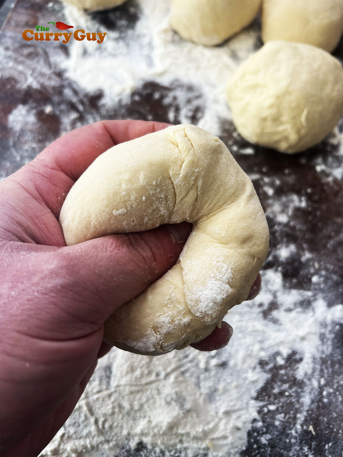 Making an indentation in the dough balls for the Peshwari filling.