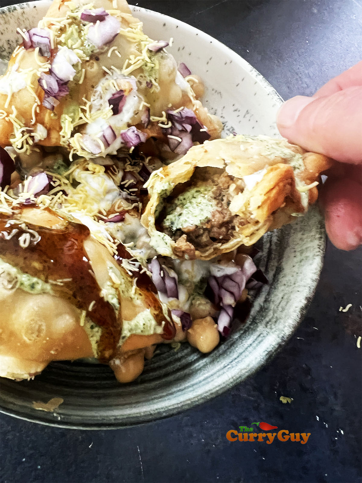Broken open samosa in a samosa chaat.