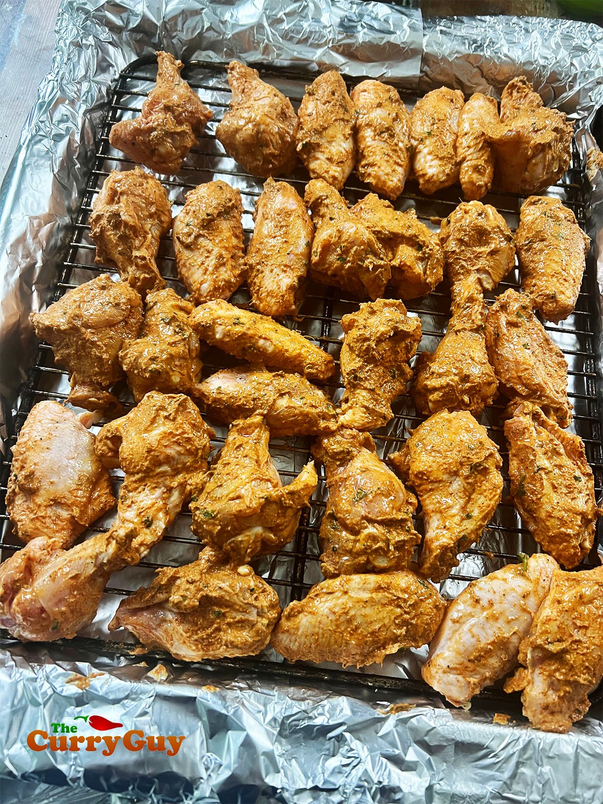 Tandoori chicken on a rack, ready for the oven.