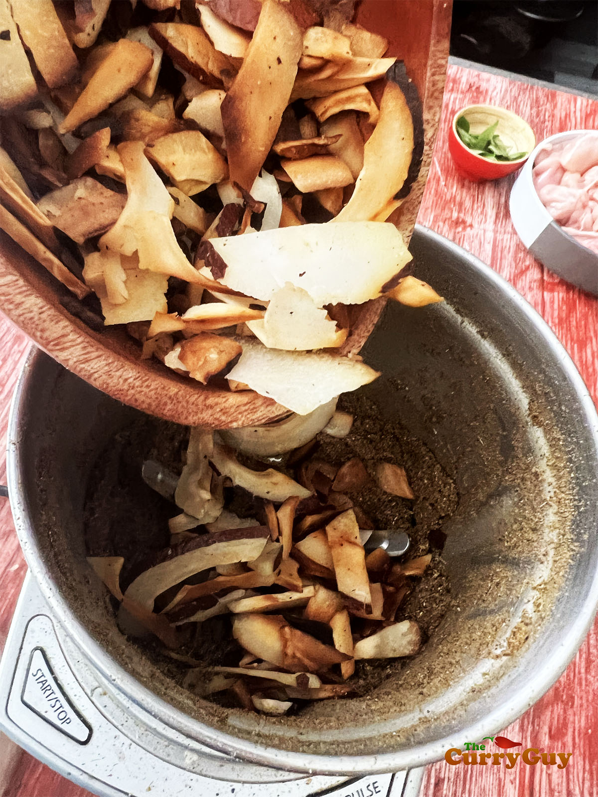 Adding the toasted coconut flakes to the ground spices