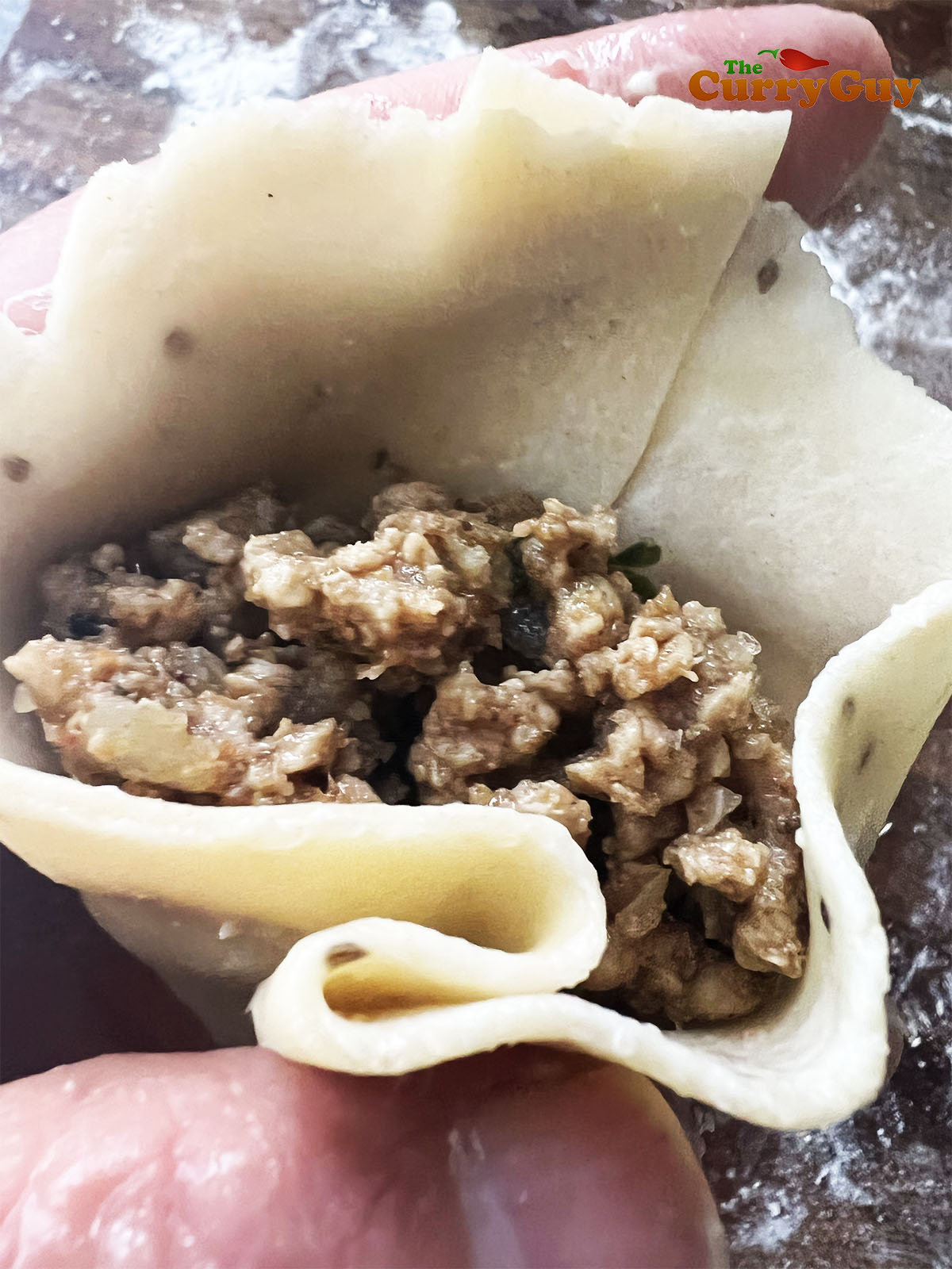 Filling the samosa with chicken mixture.
