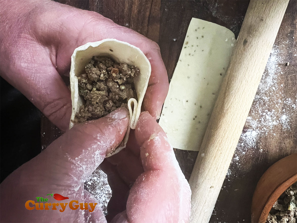 Creating a pleat with the dough.
