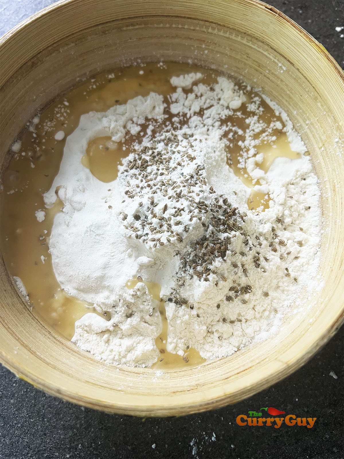 Adding oil to the flour and salt for the samosa pastry.