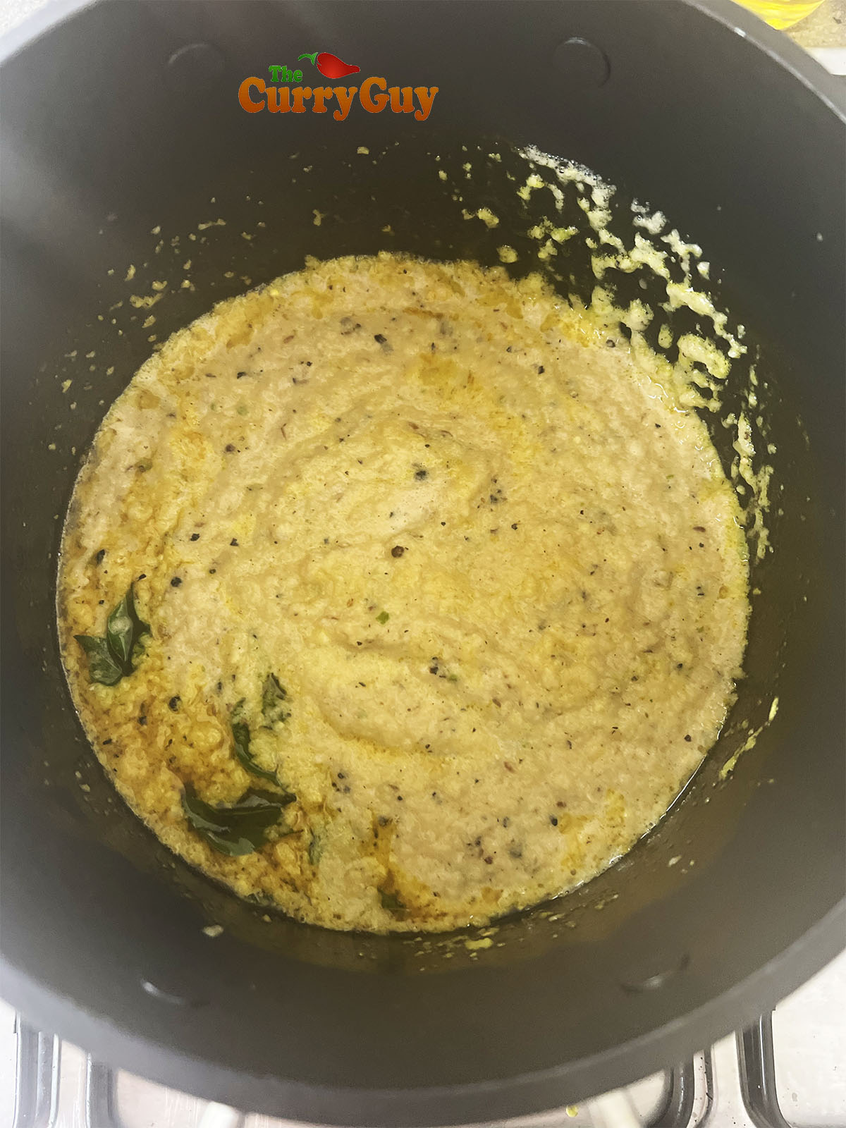 Adding the spice paste to the oil to fry.