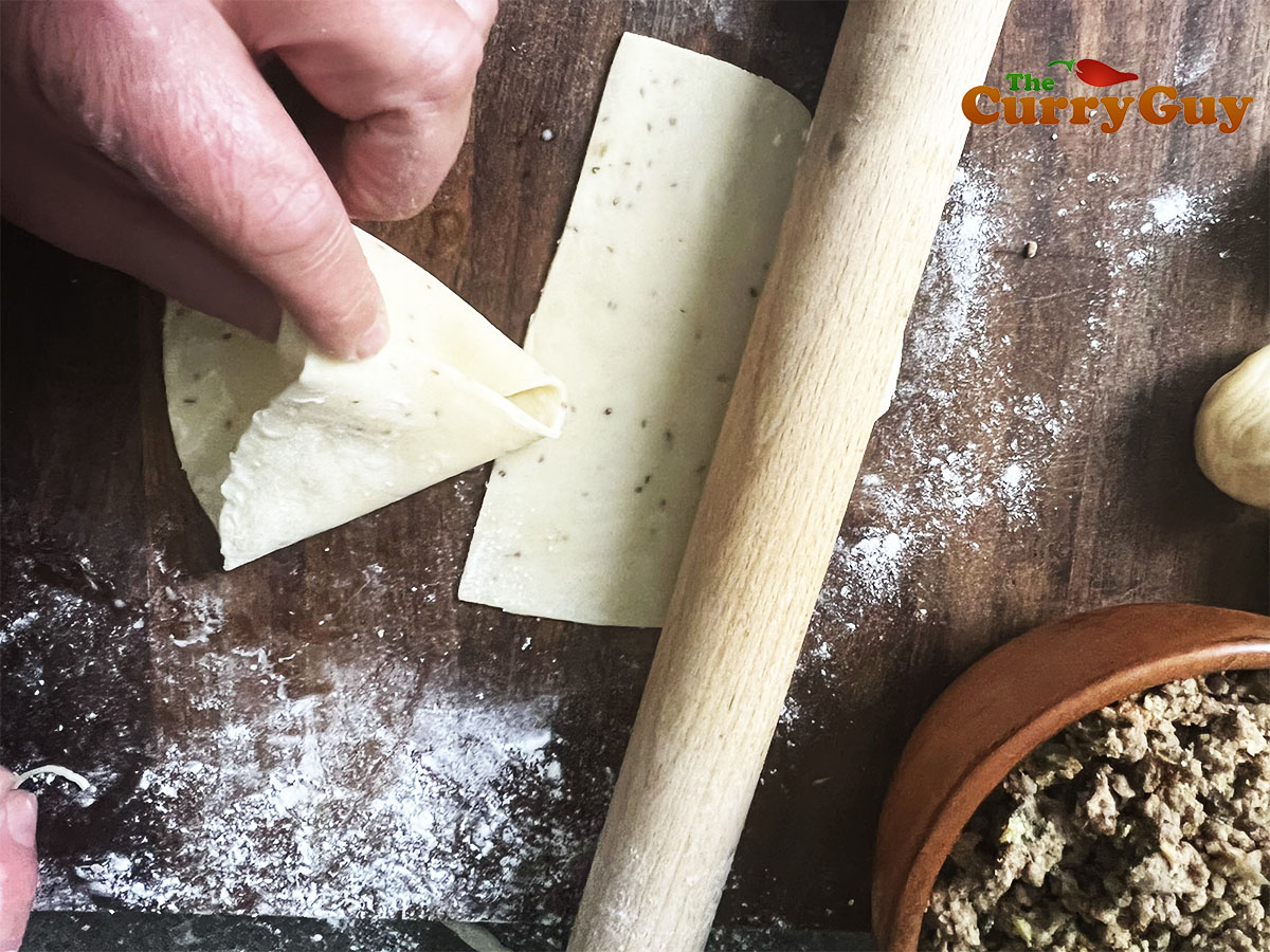 Folding the samosa pastry.