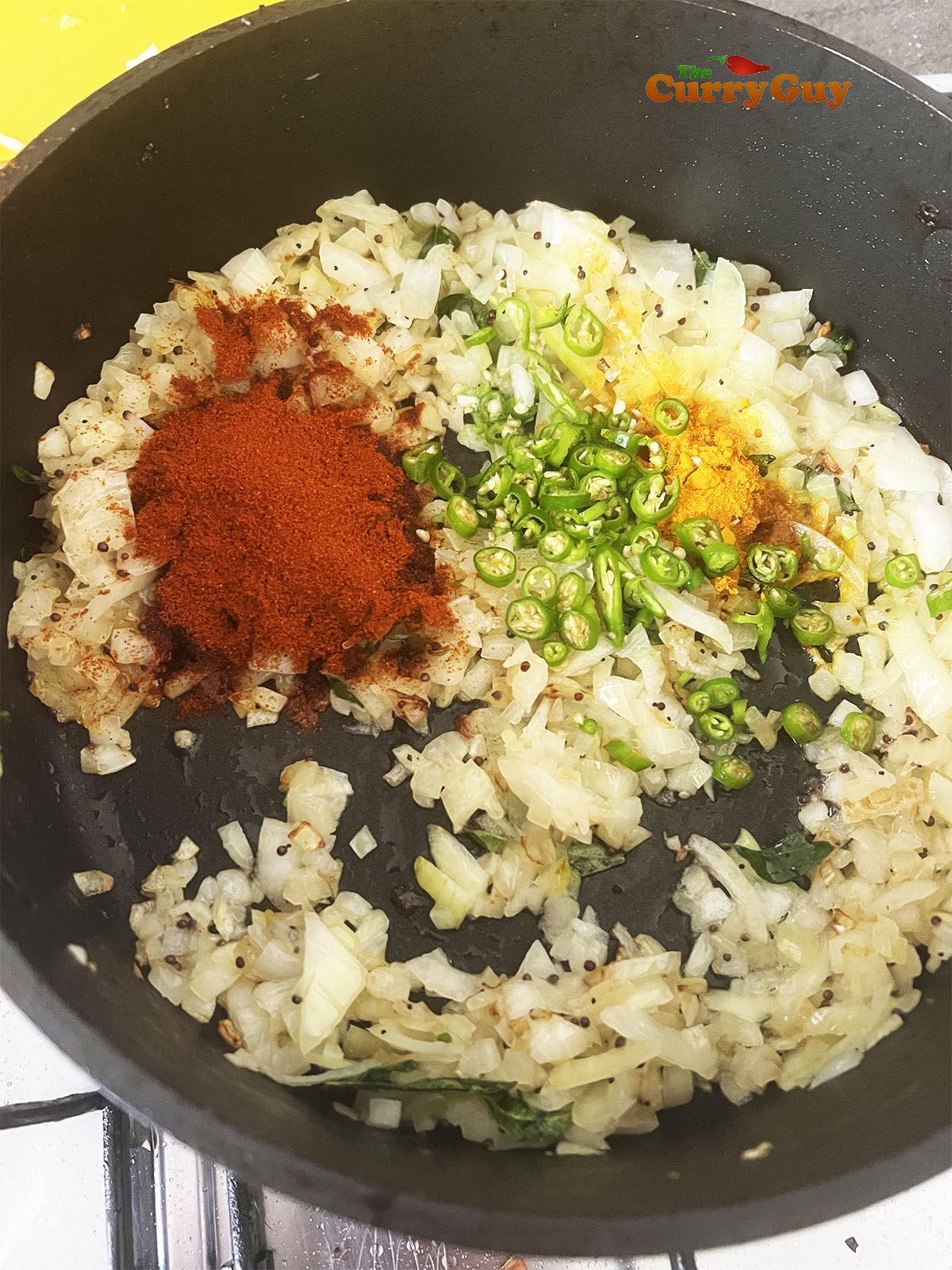 Adding onions and frying them. Then adding ground spices and chillies.