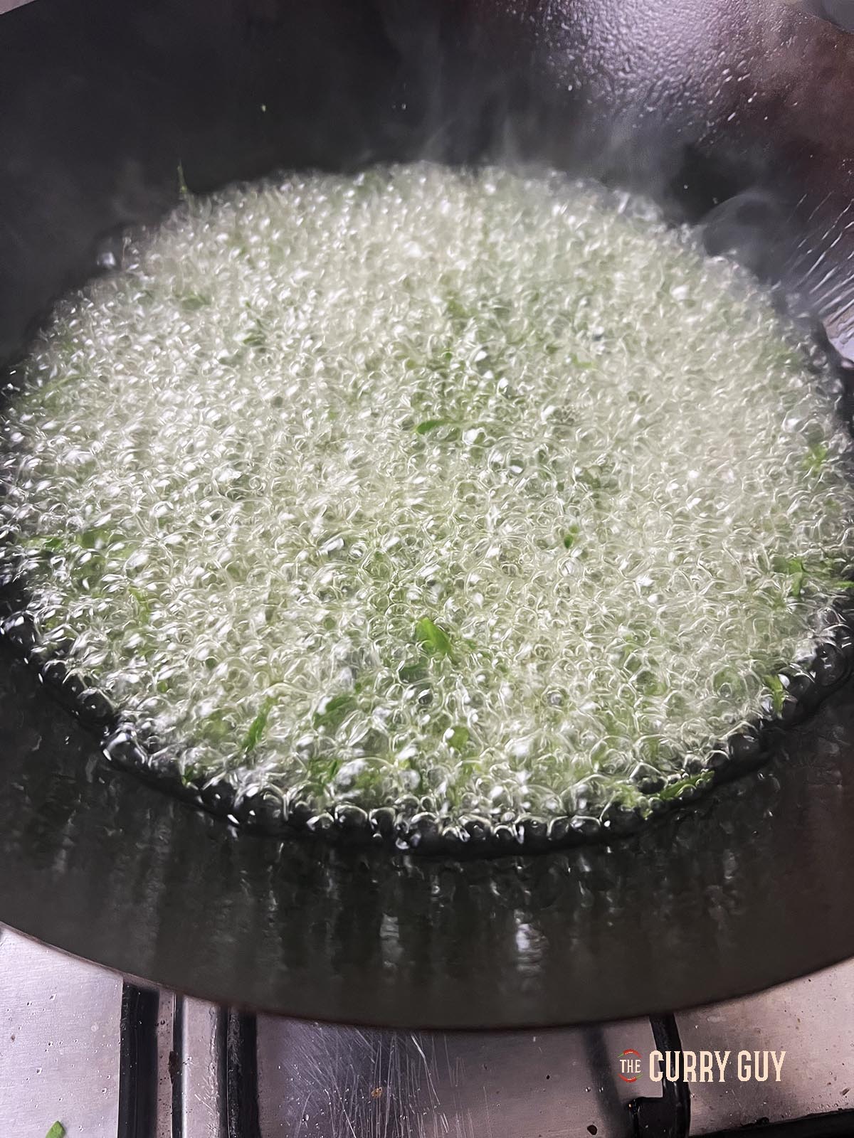 Spinach frying in the oil