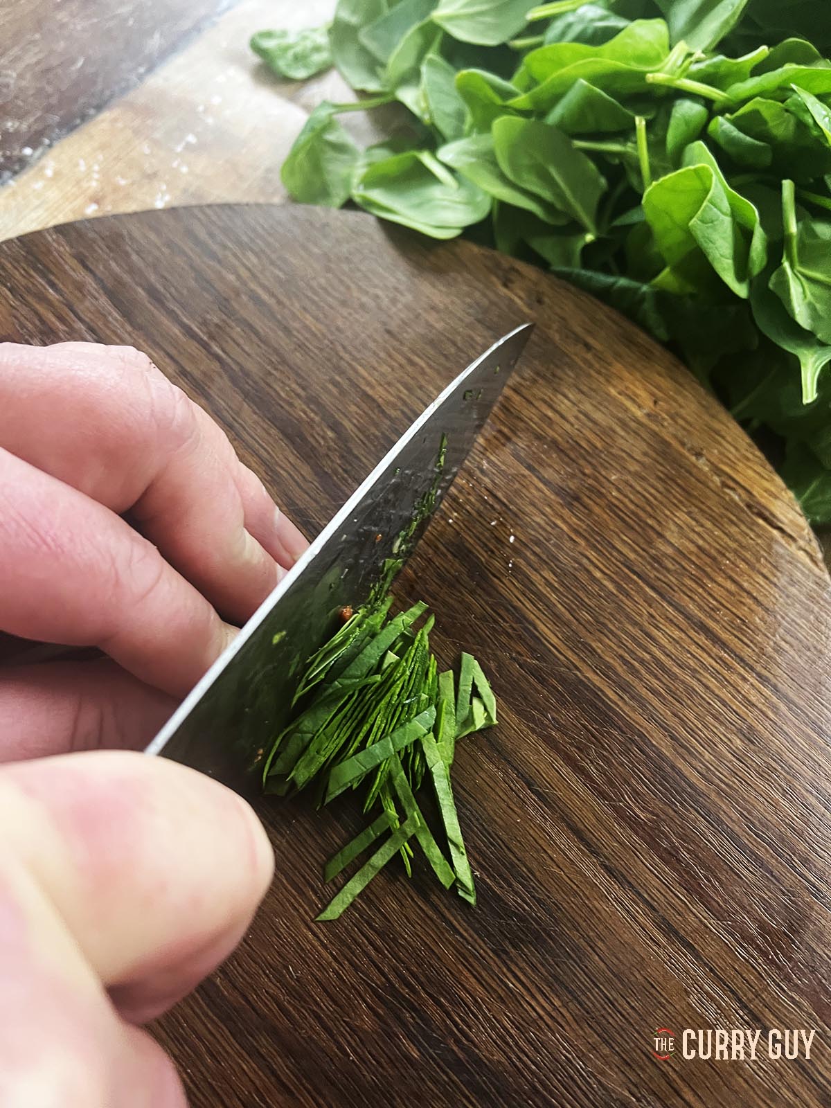 Thinly slicing the spinach leaves.