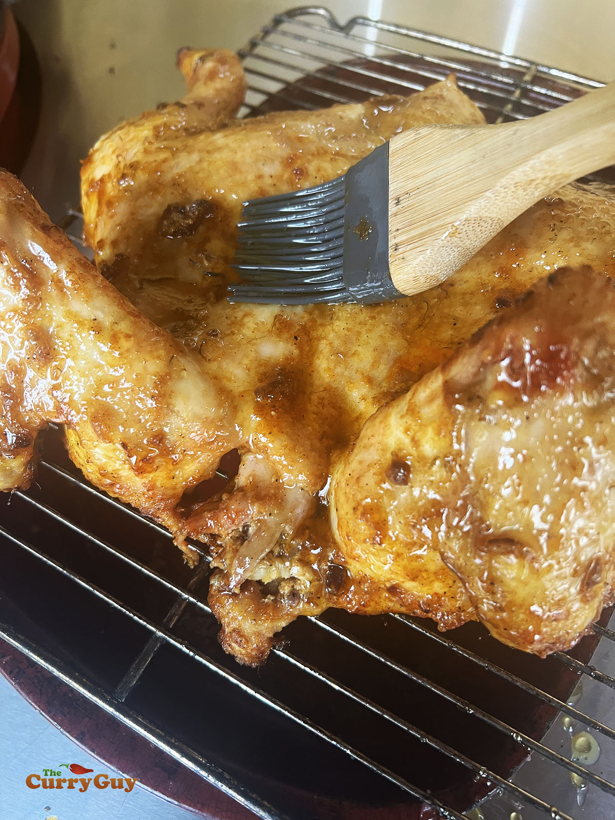 Applying the ghee and honey mixture to the chicken.