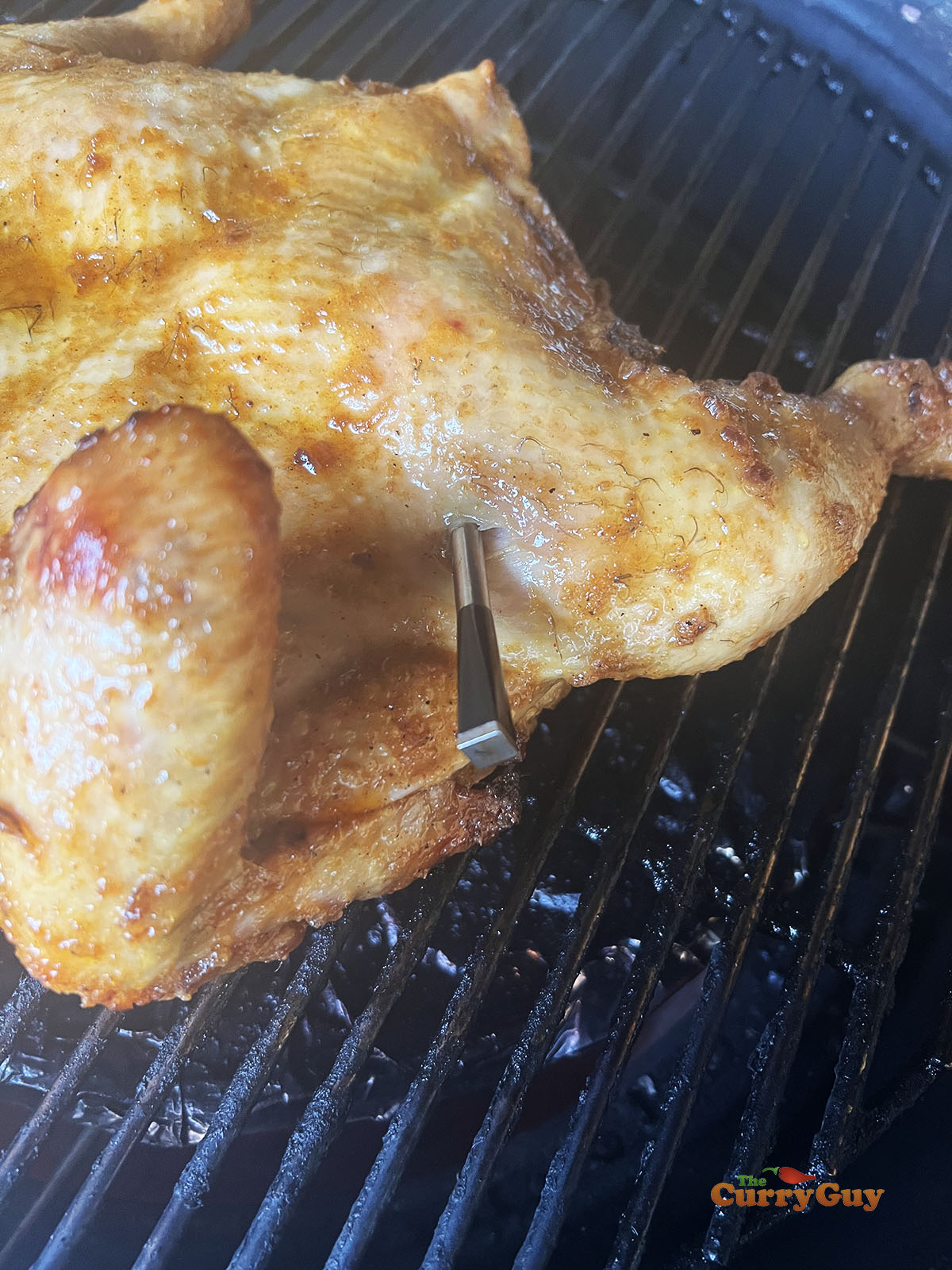 Placing the honey roast chicken back on the cooking grate.