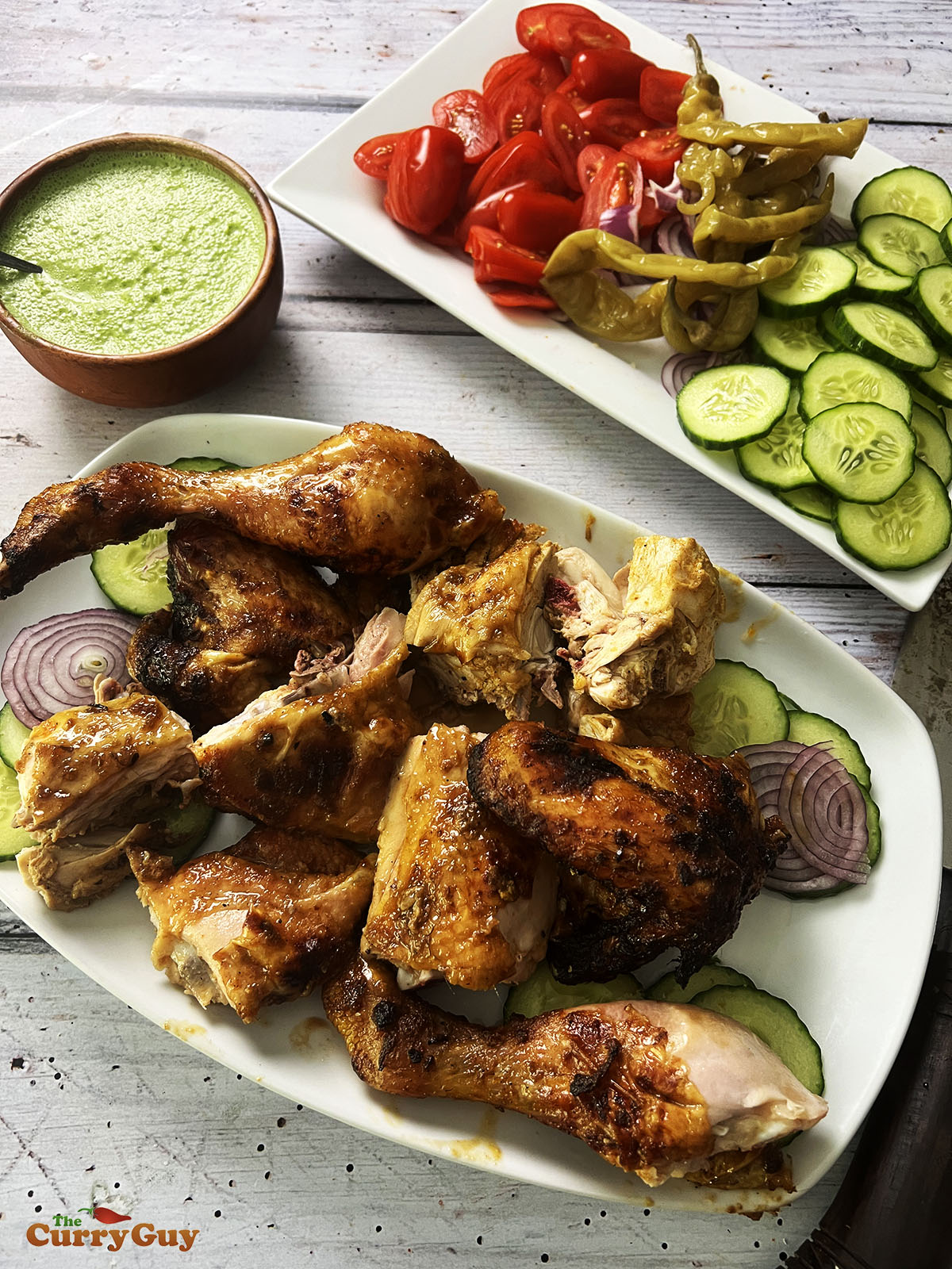 Honey roast chicken on a serving plate with vegetables.