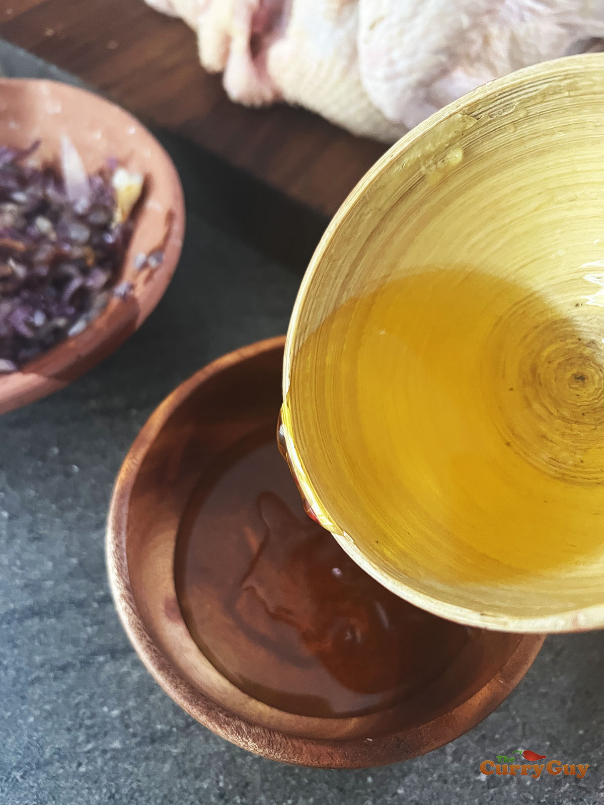 Pouring the melted ghee from the pan into the honey.