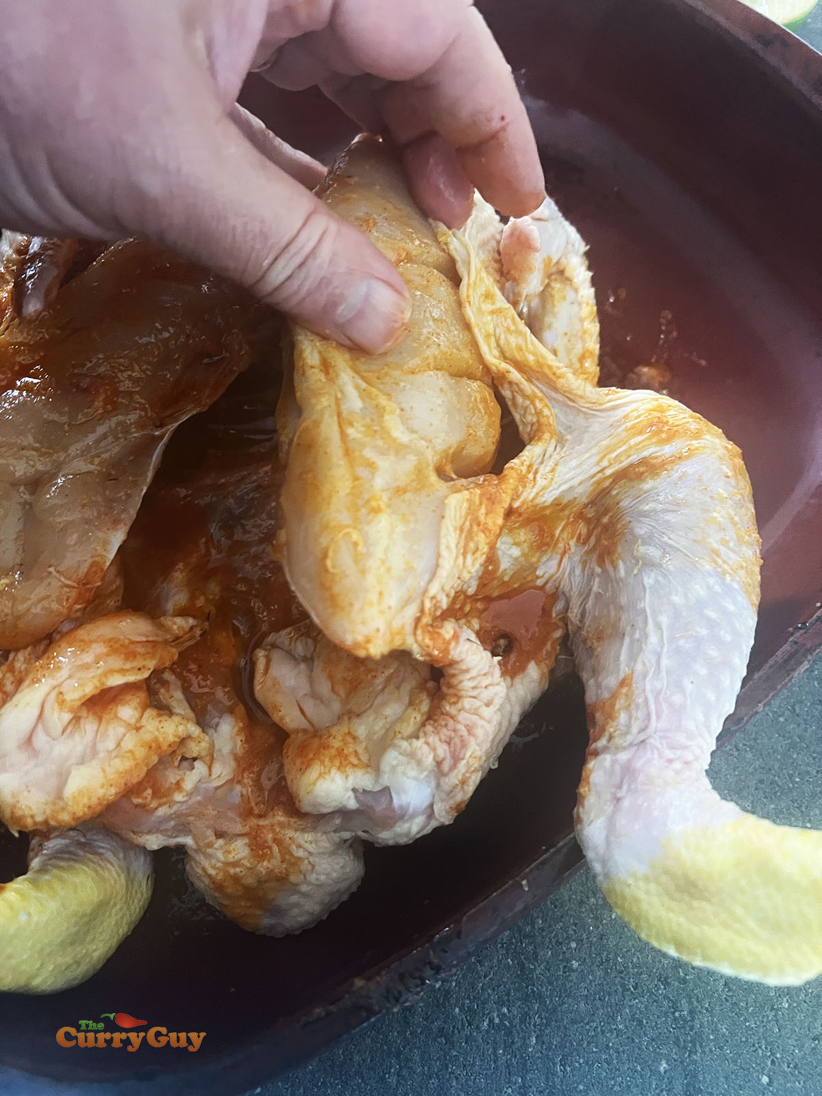 Applying the first marinade to the chicken.