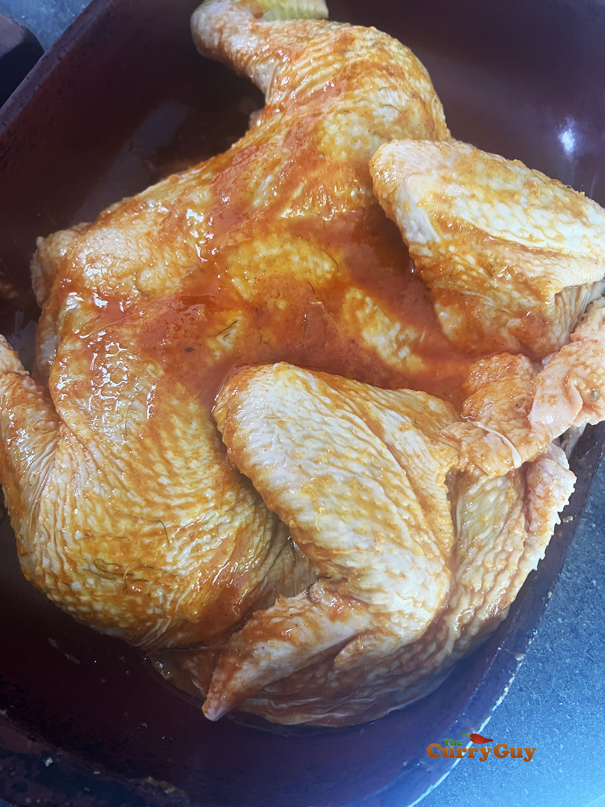 Applying the marinade all over the chicken including in the slits in the meat.