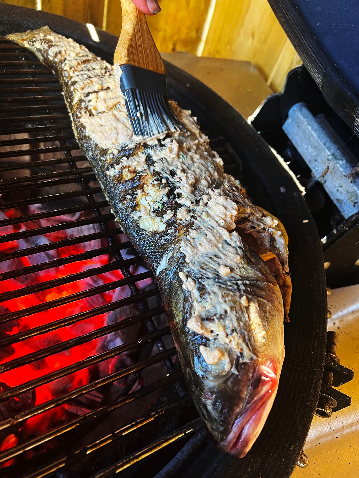 Basting the fish with marinade.