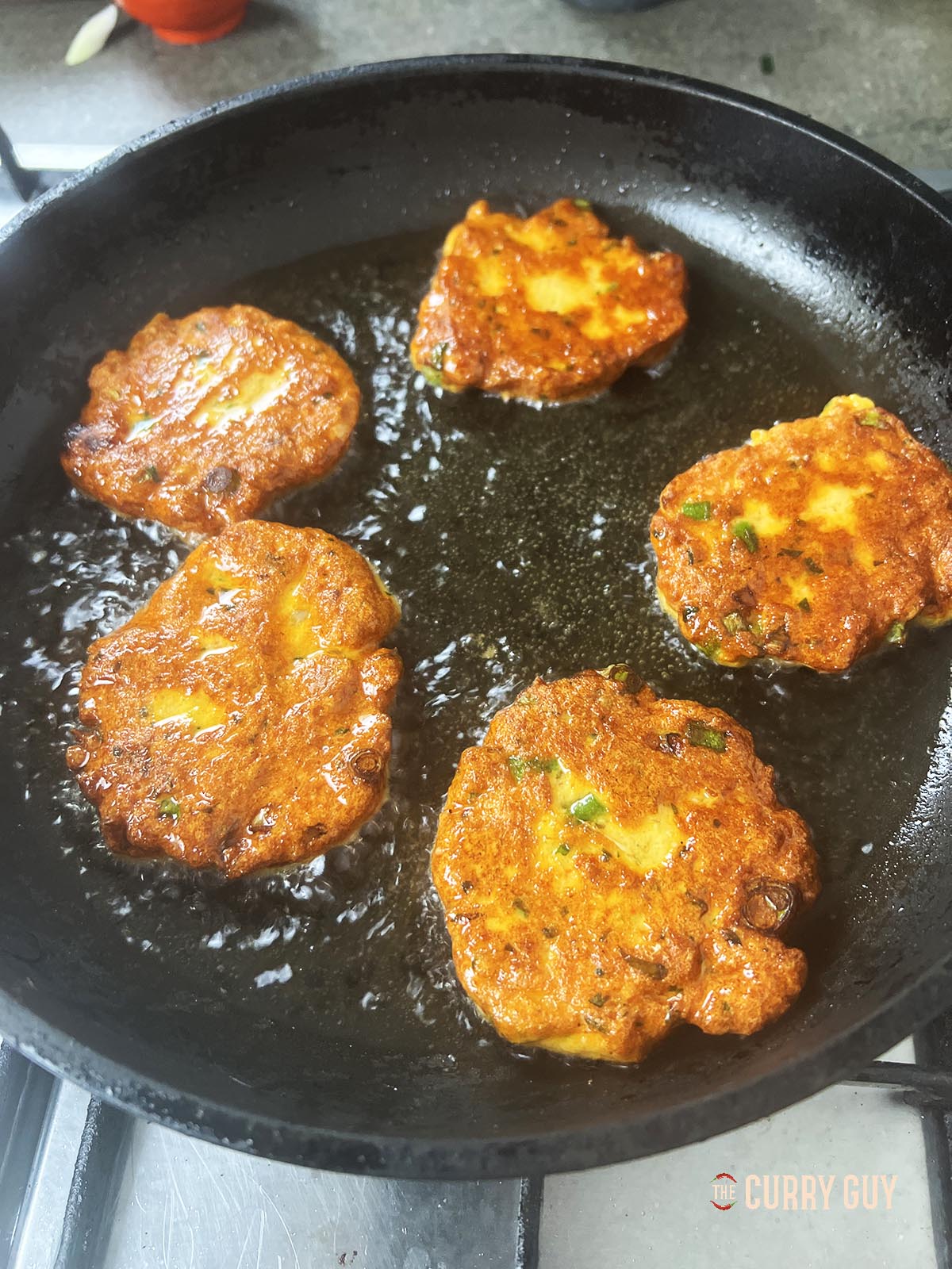 Frying the other side of the Thai fish cakes.
