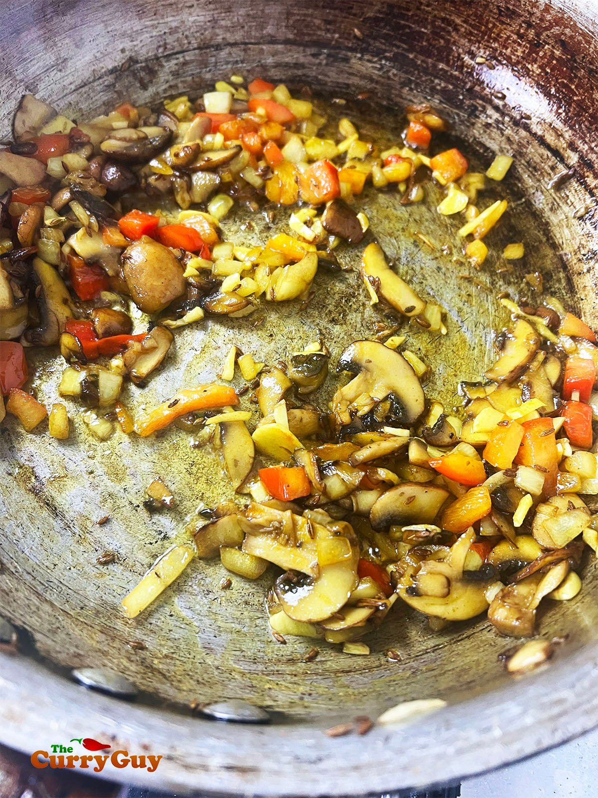 Adding chopped bell pepper and turmeric to the pan.