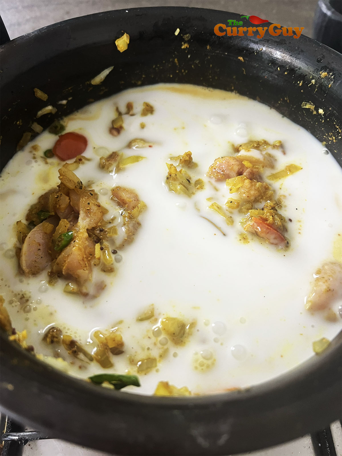 Adding the coconut milk to the pot.