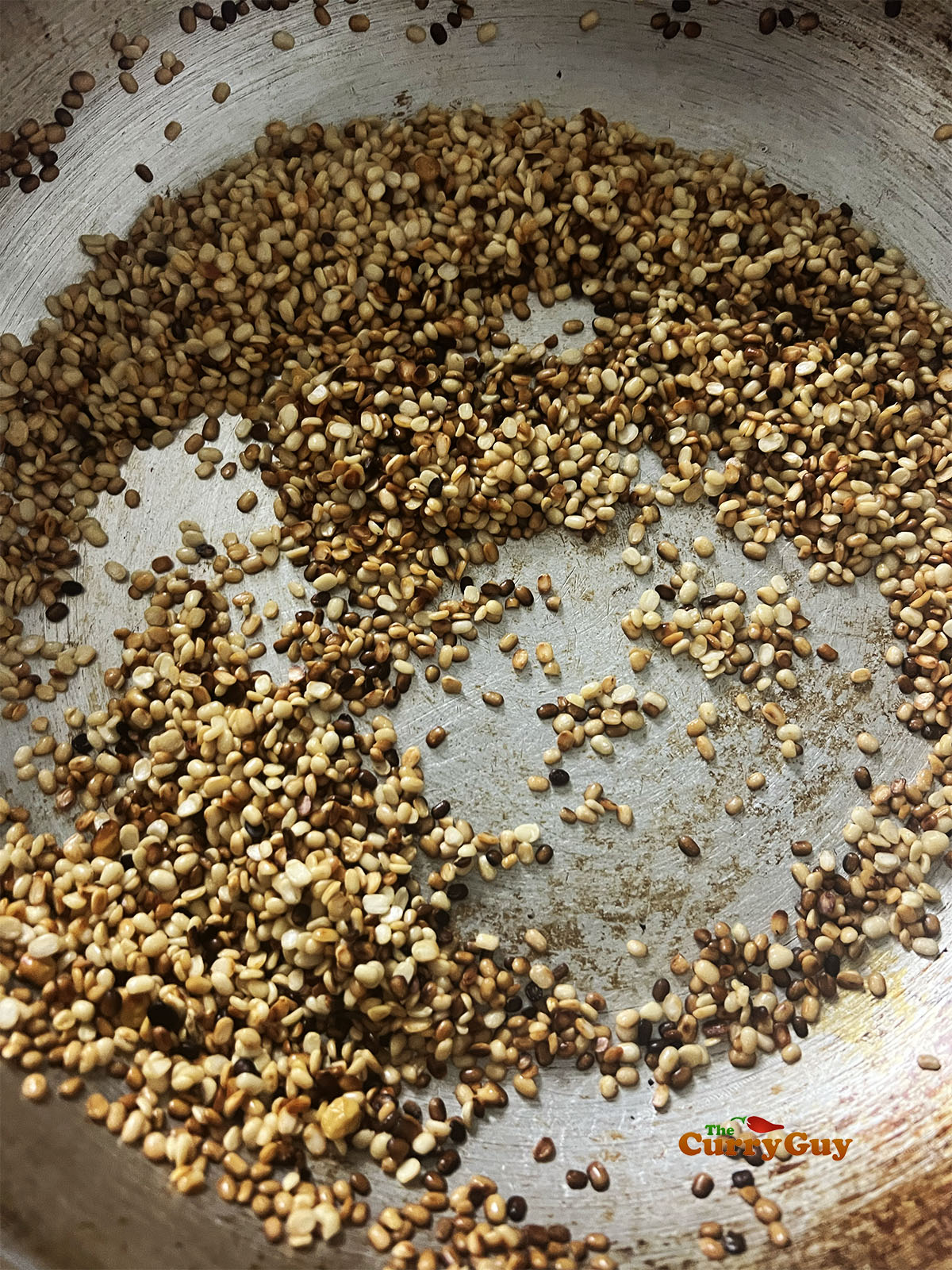 Toasting the chana lentils in the pan until golden brown.
