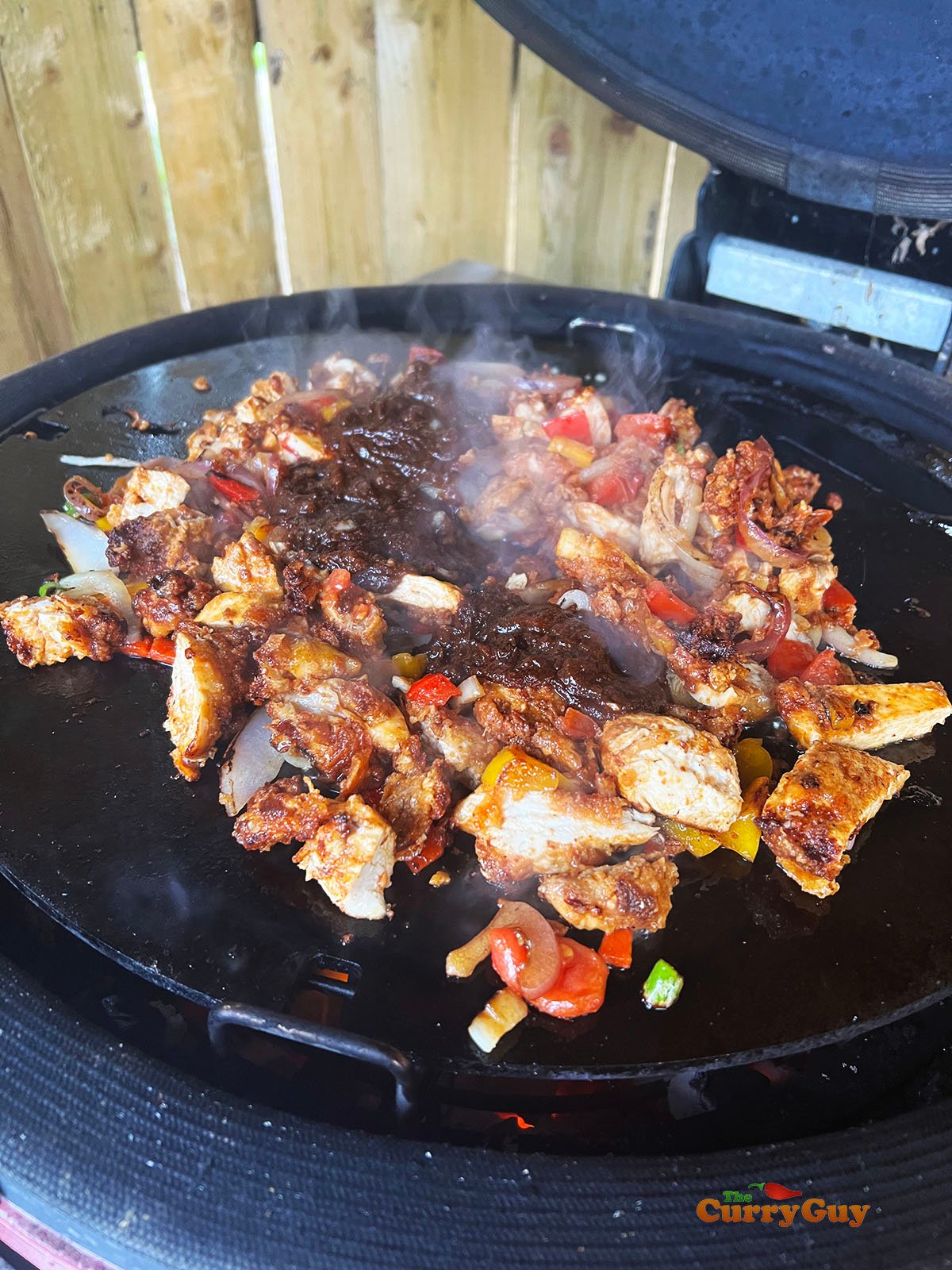 Frying veggies, chicken and onion sauce.