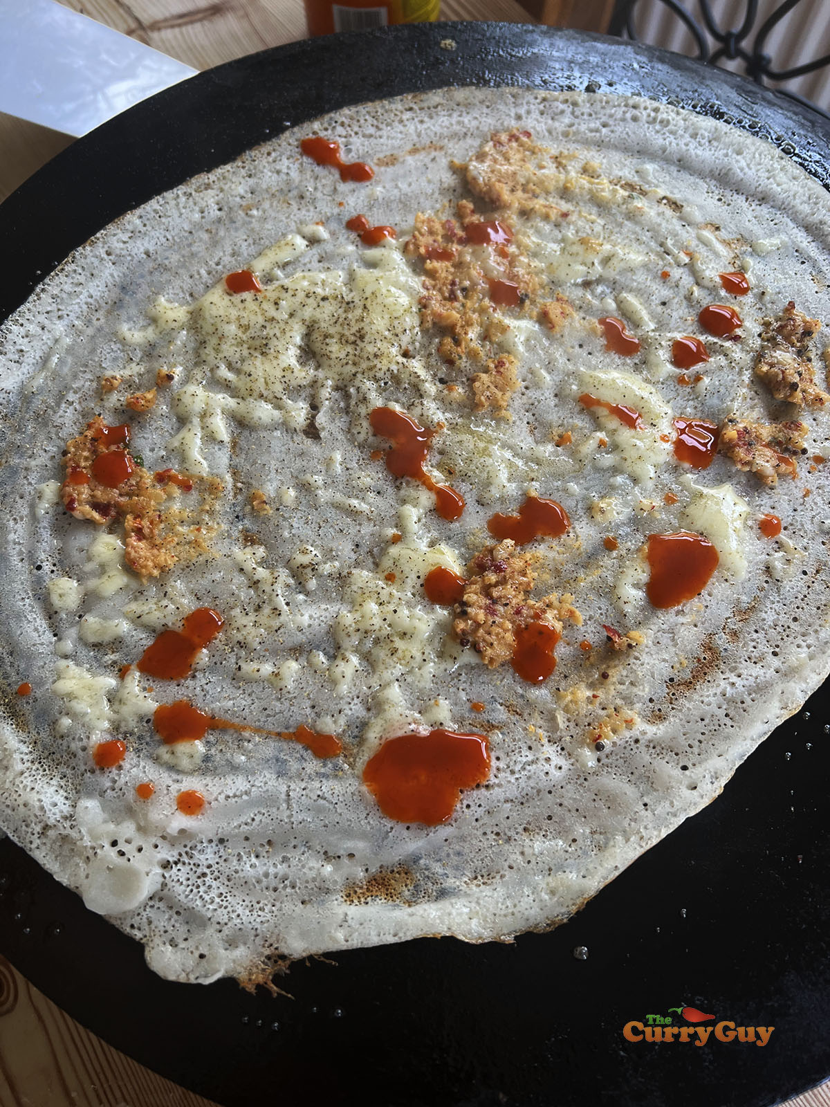 Dosa with cheese, garlic chutney and hot sauce