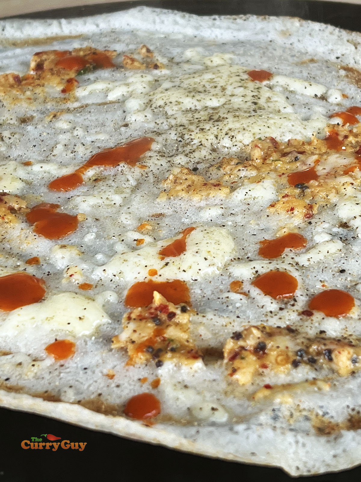 Cheese topped dosa with black pepper.