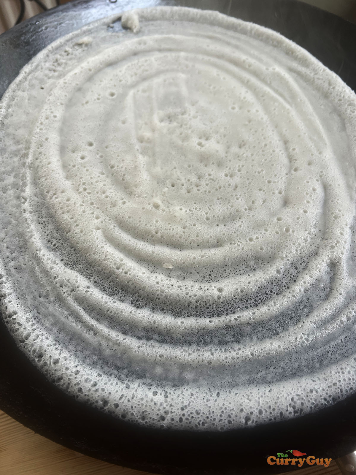 Spreading the dosa batter.