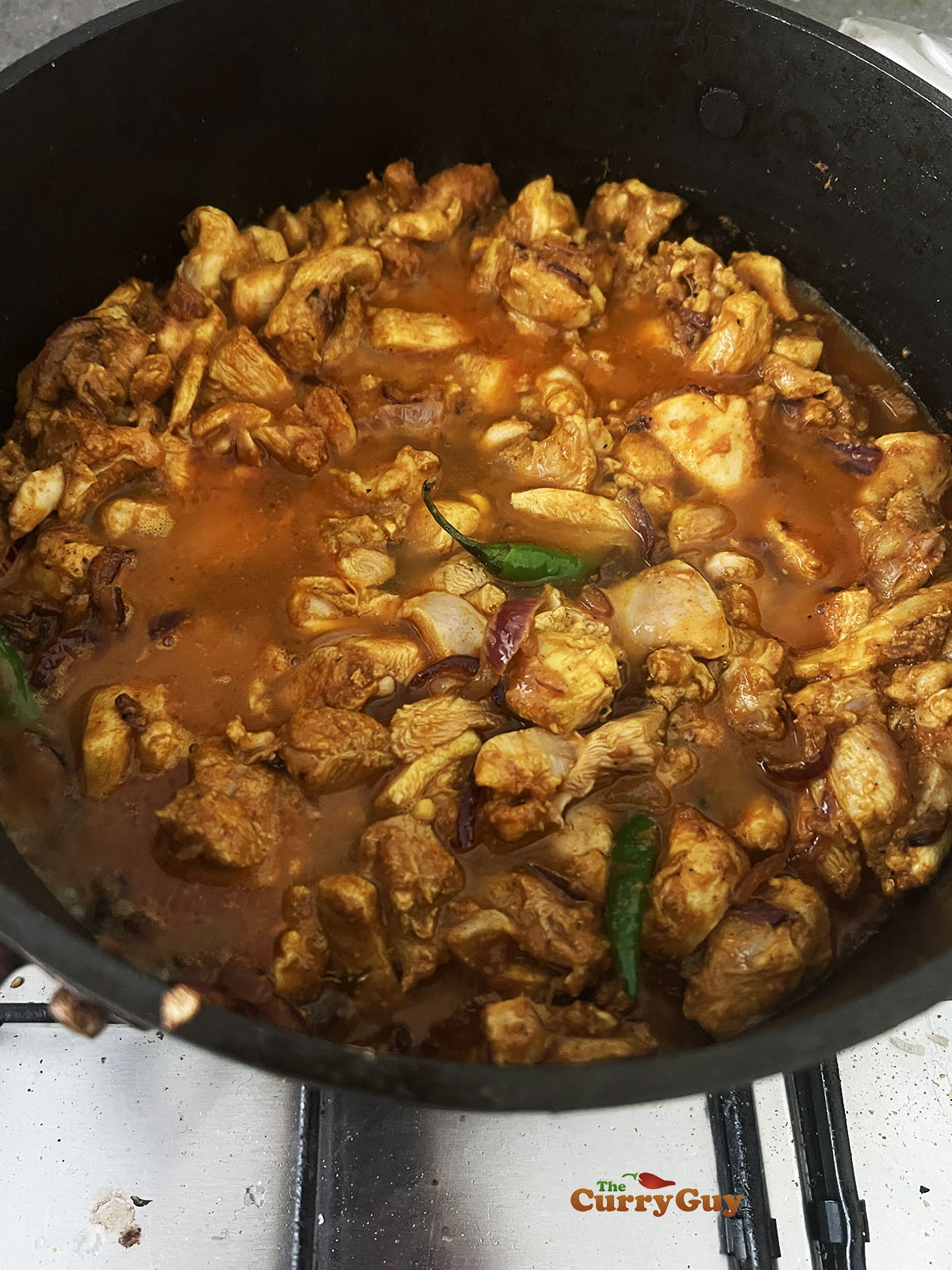 Simmering the chicken in a pan.
