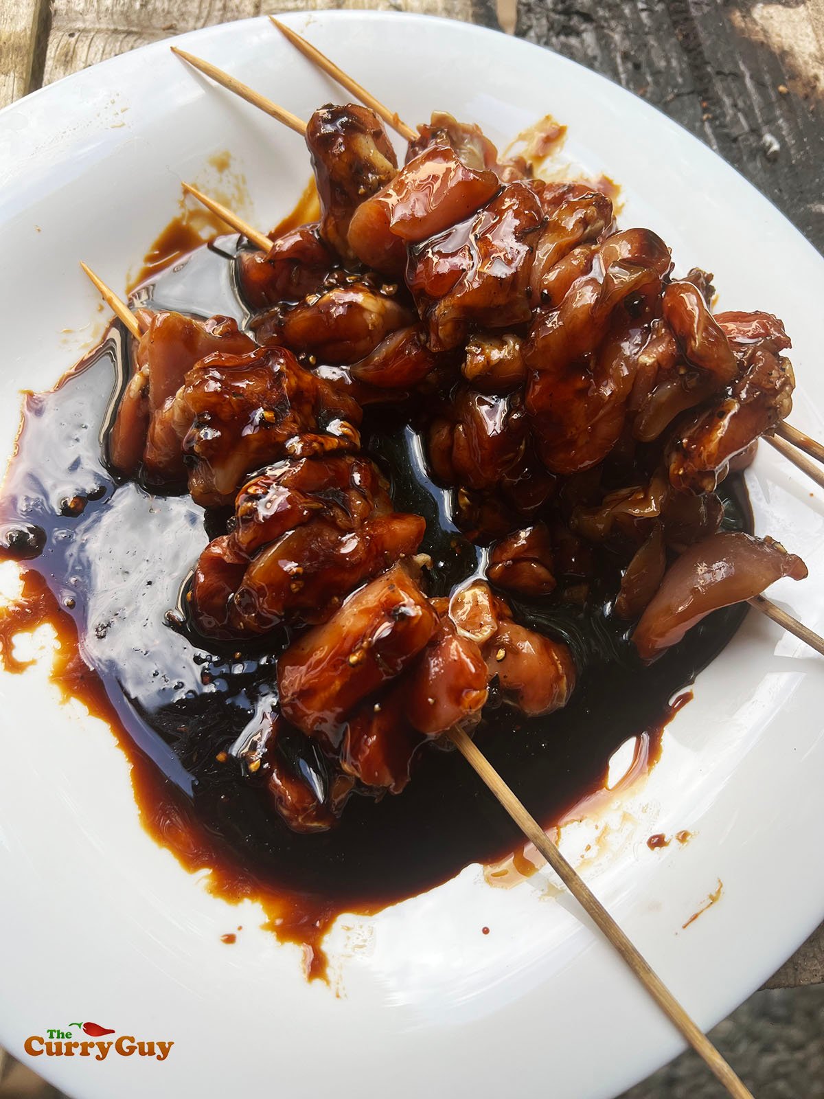 Dipping the chicken skewers in kecap manis