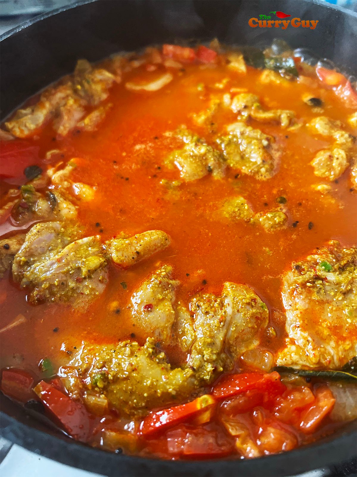 Adding the chicken and its marinade along with enough water to cover.