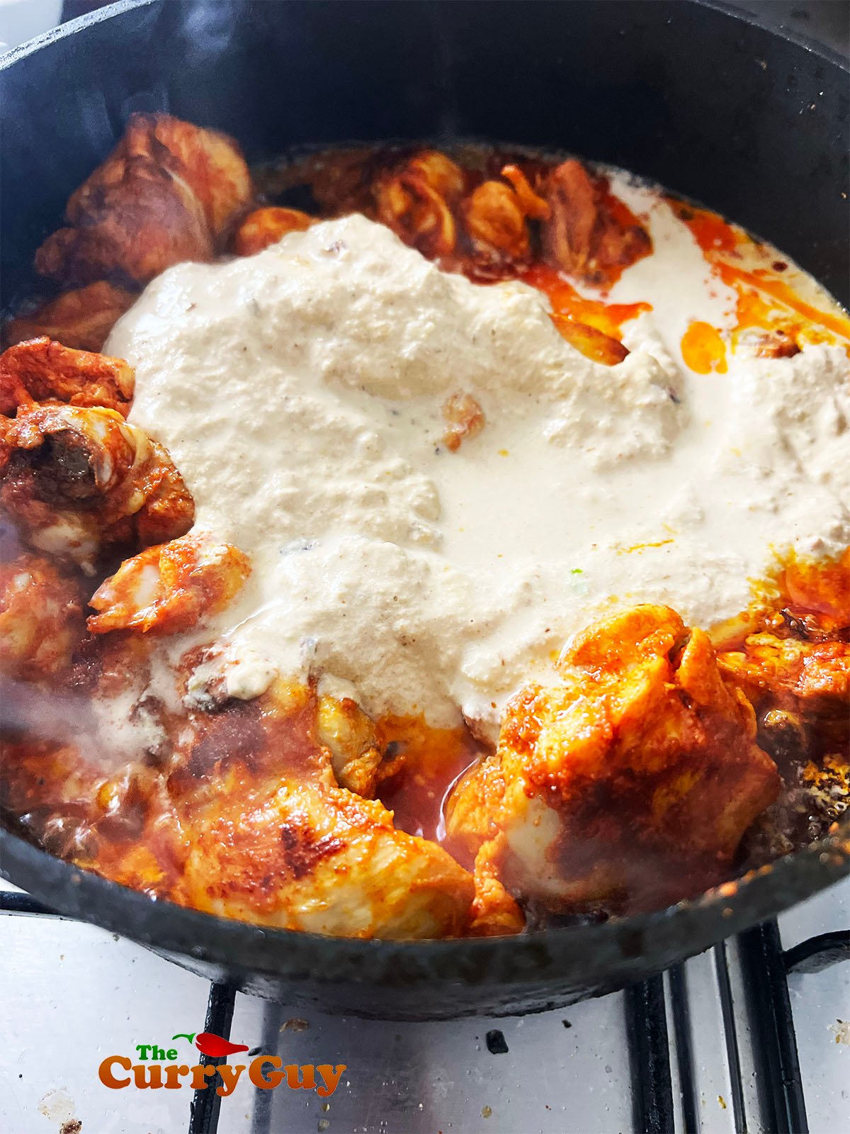 Adding the korma paste to the fried chicken.