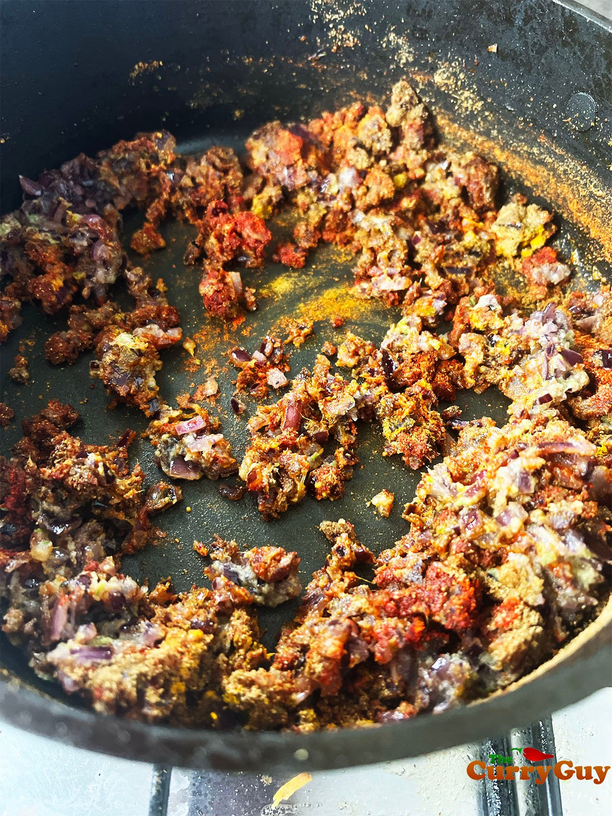 Adding the ground spices to the pan.
