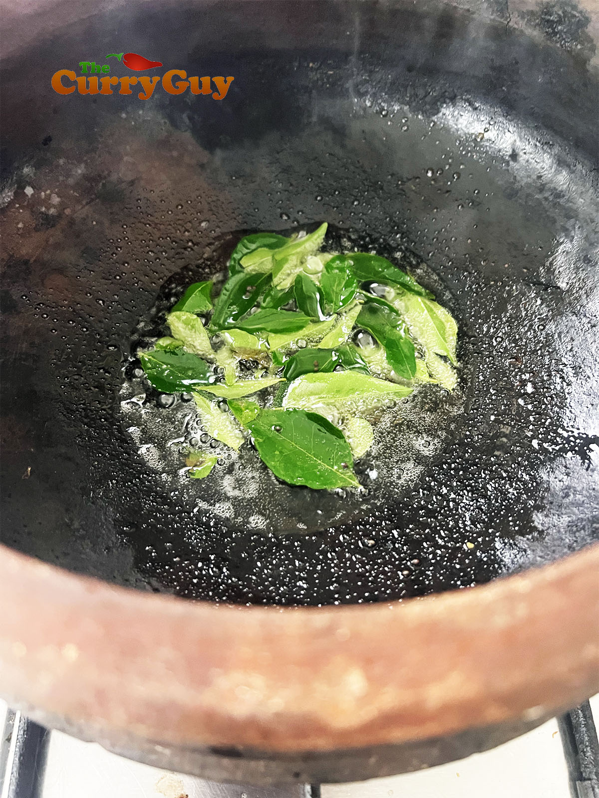 Infusing mustard seeds and curry leaves in the hot oil.