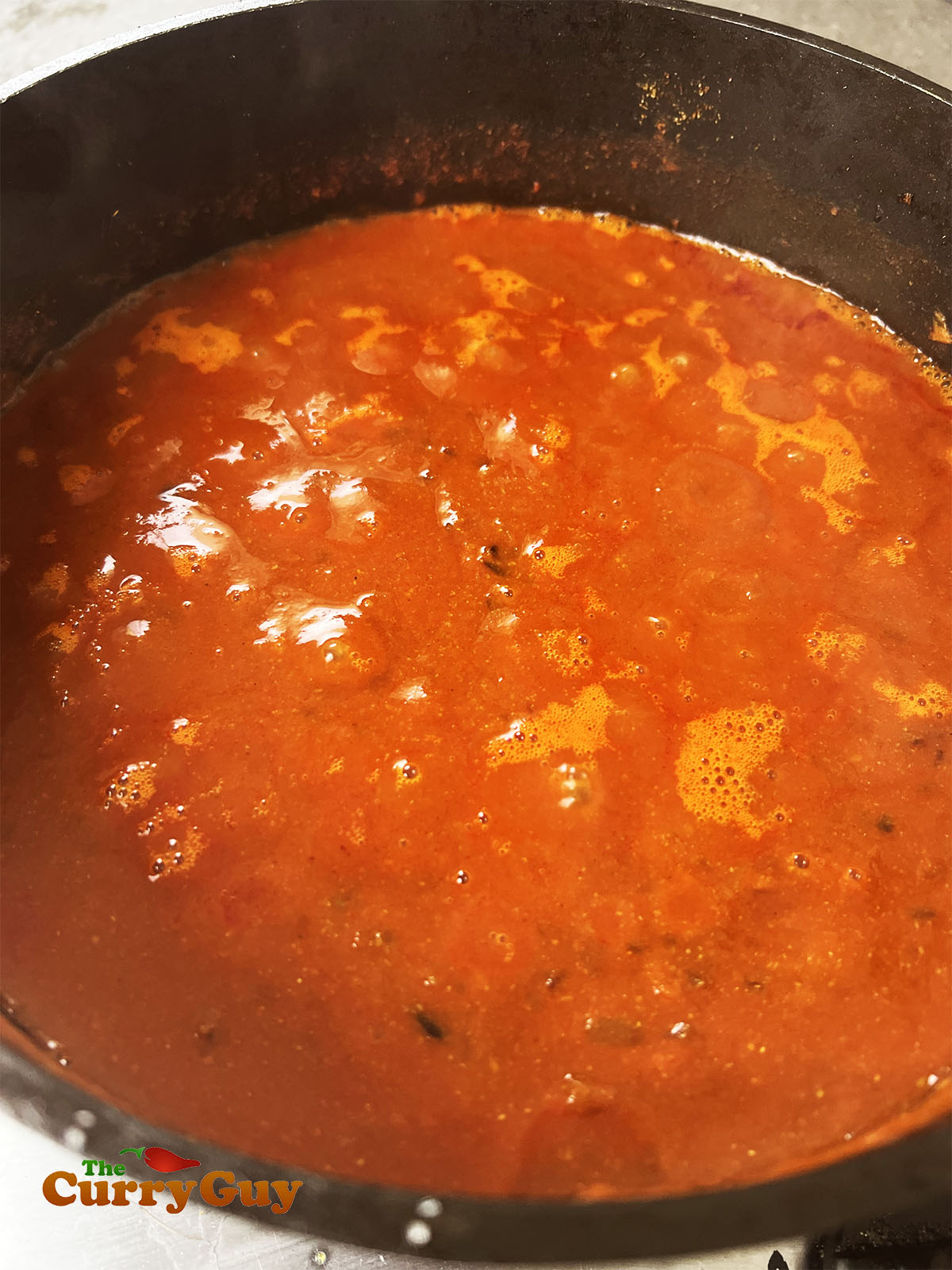 Adding the water or chicken stock to the pan to simmer.