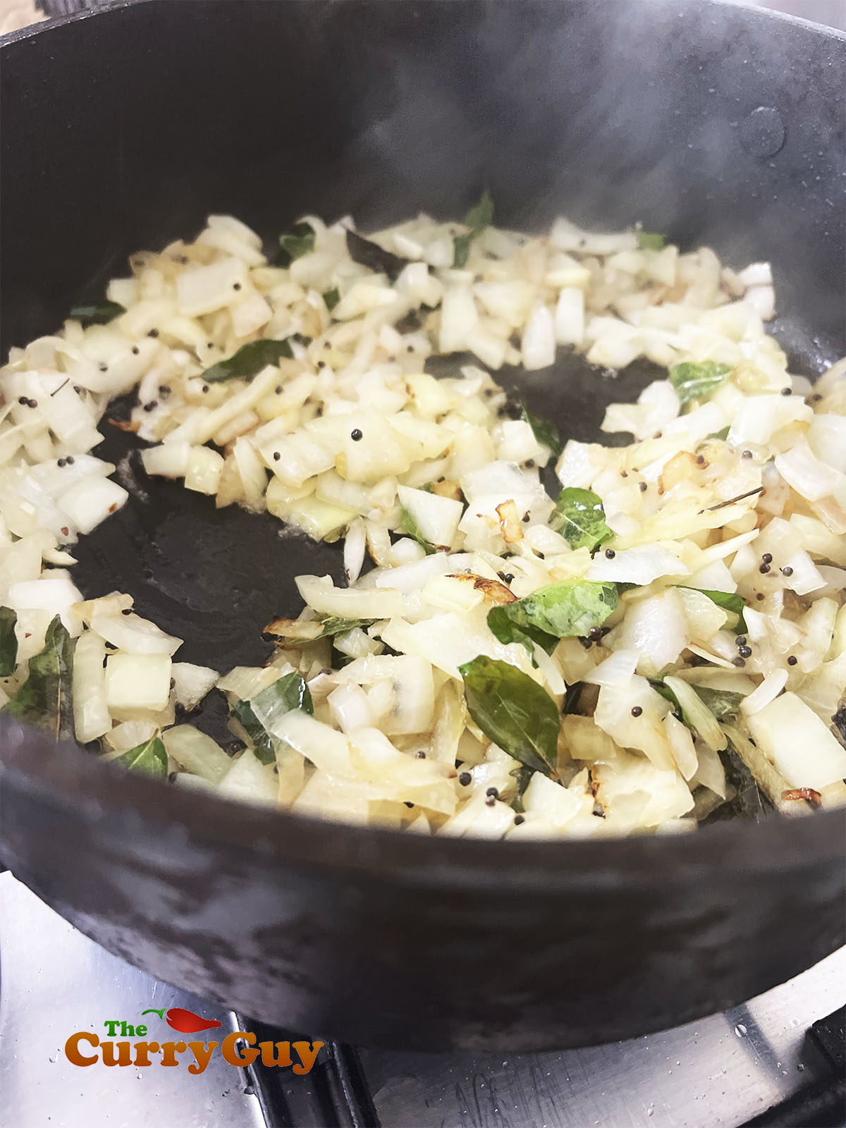 Adding chopped onions to the pan.