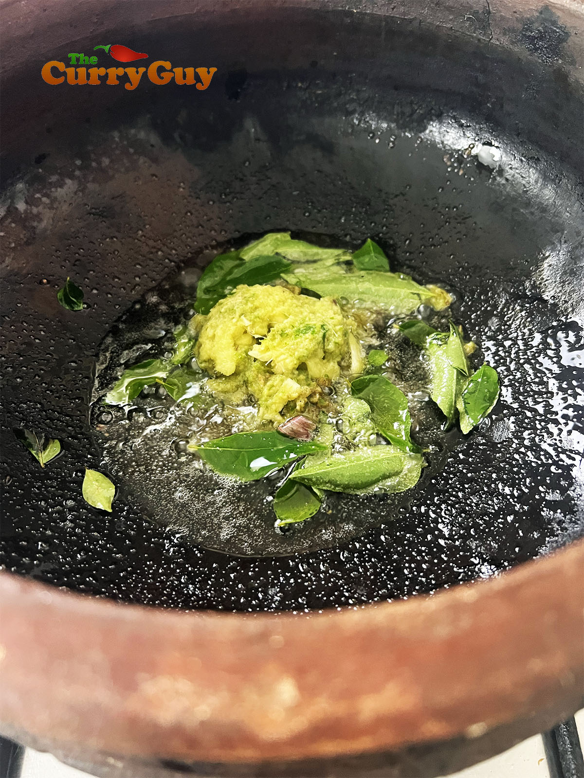 Stiring garlic, ginger and chilli into the oil.