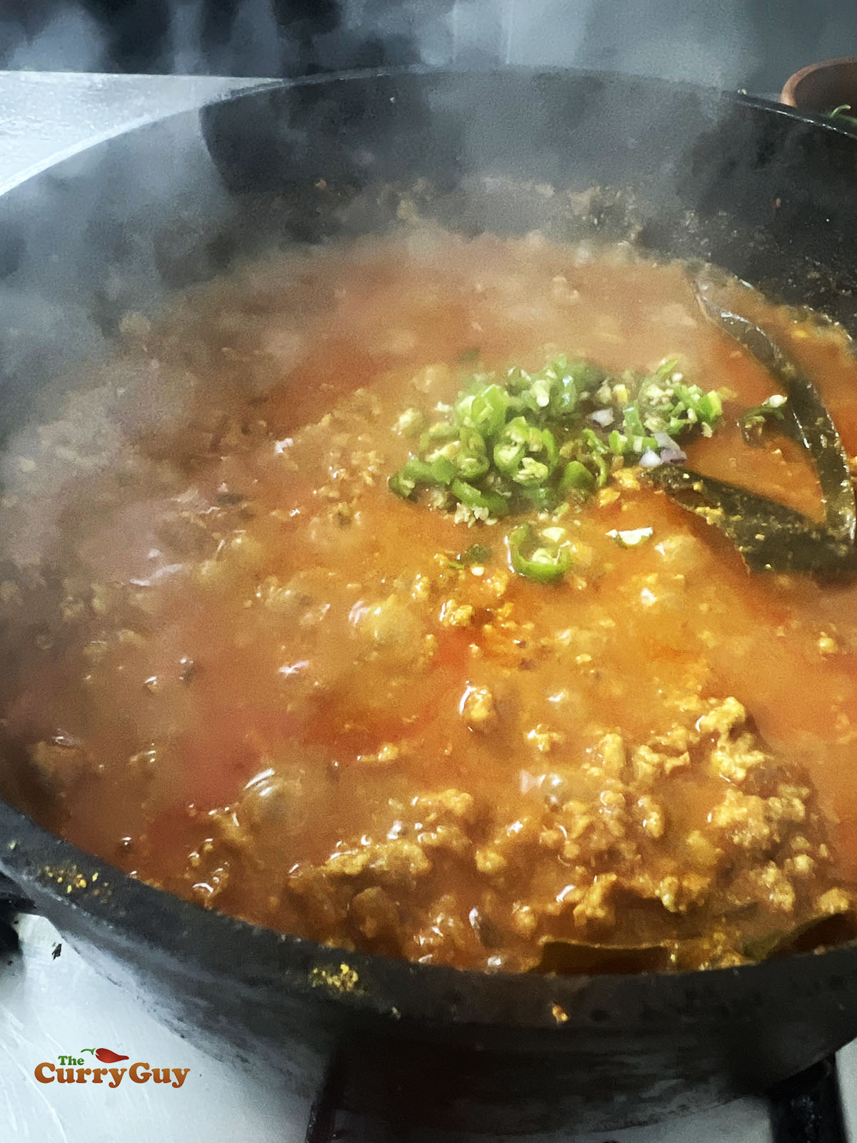 Adding fresh, chopped chillies to the pan.