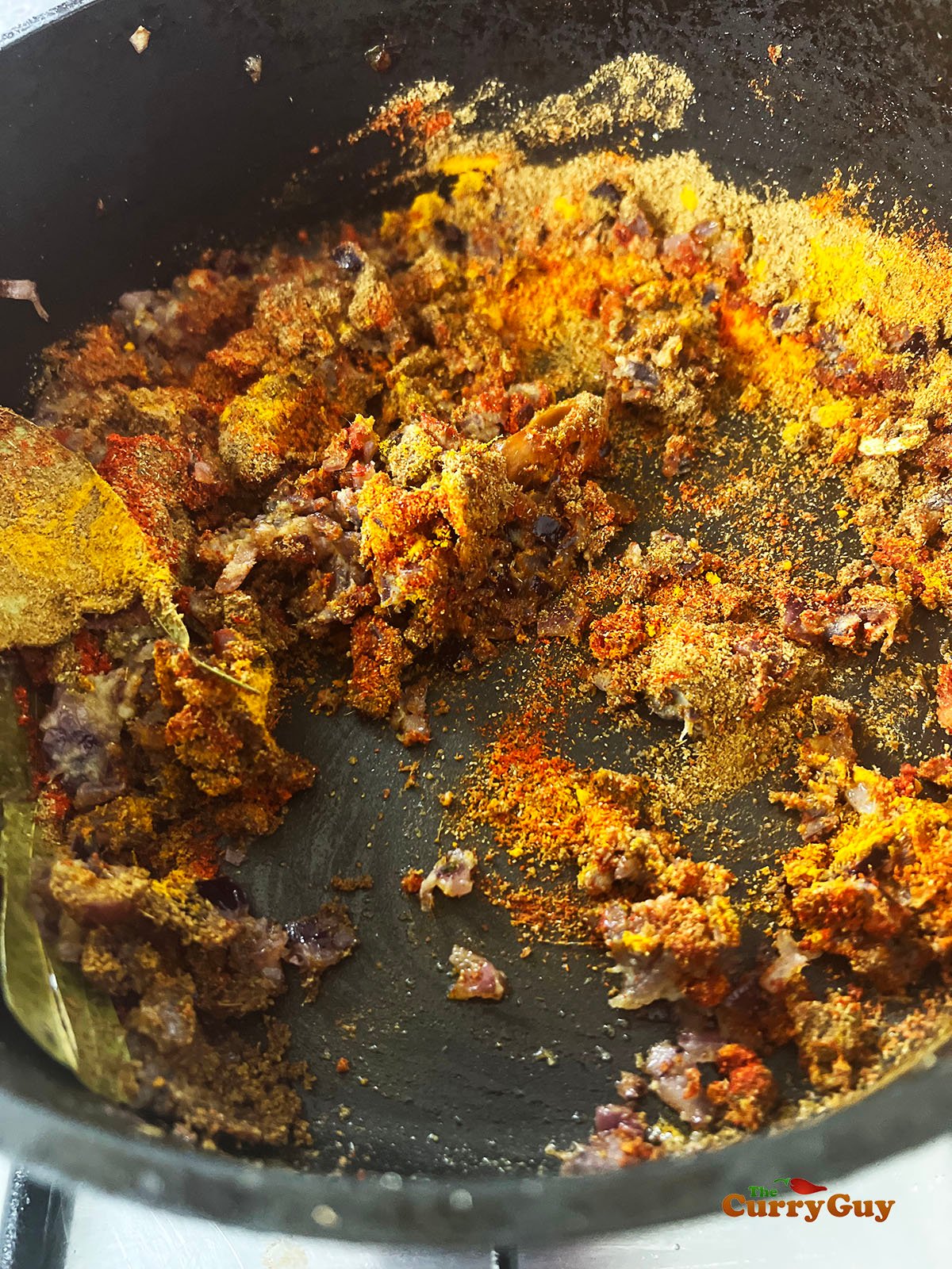 The spices being mixed into the onions.