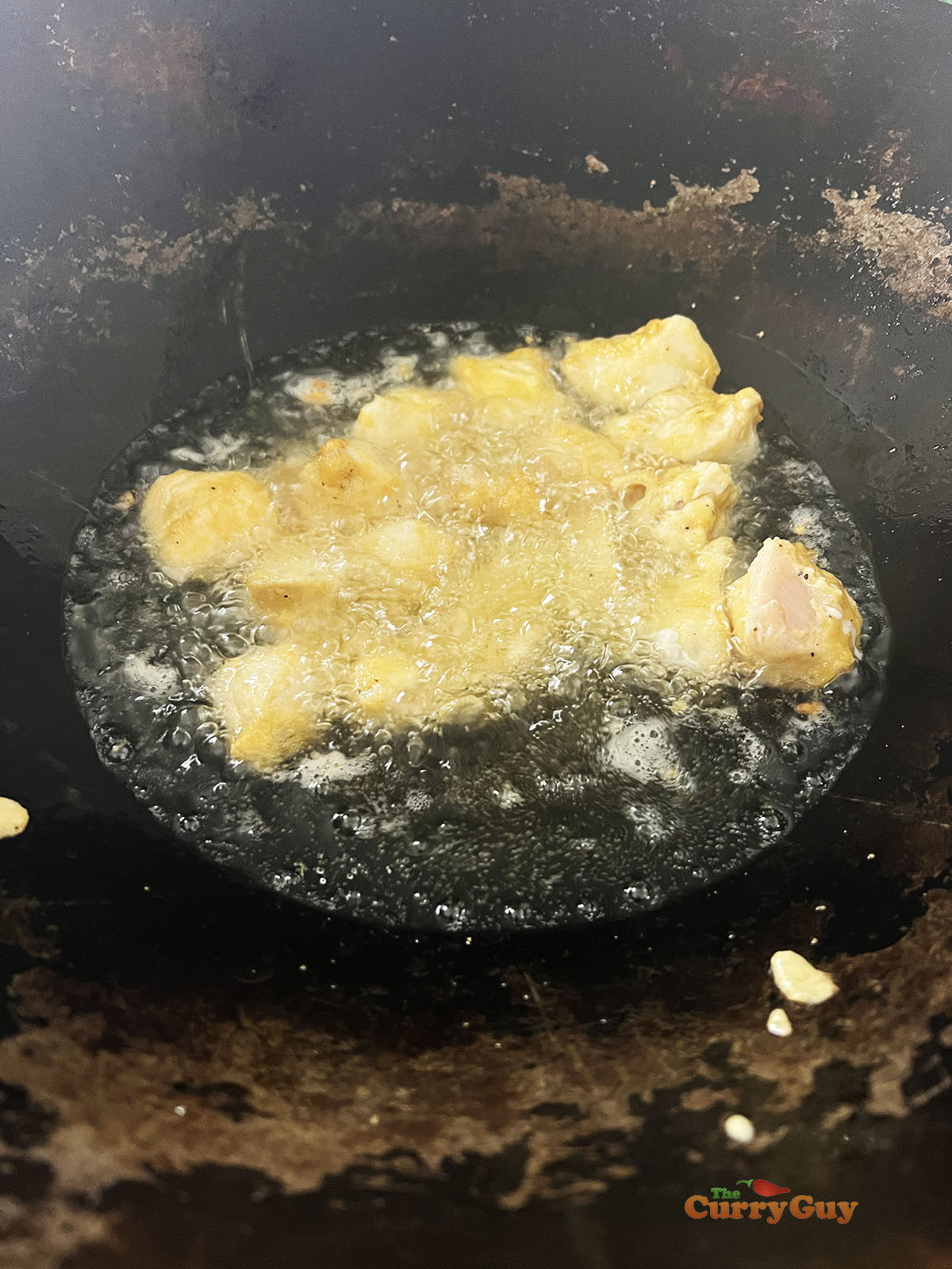Frying the marinated chicken.