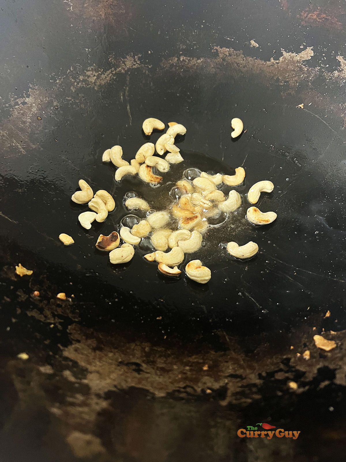 Frying the raw cashews until brown.
