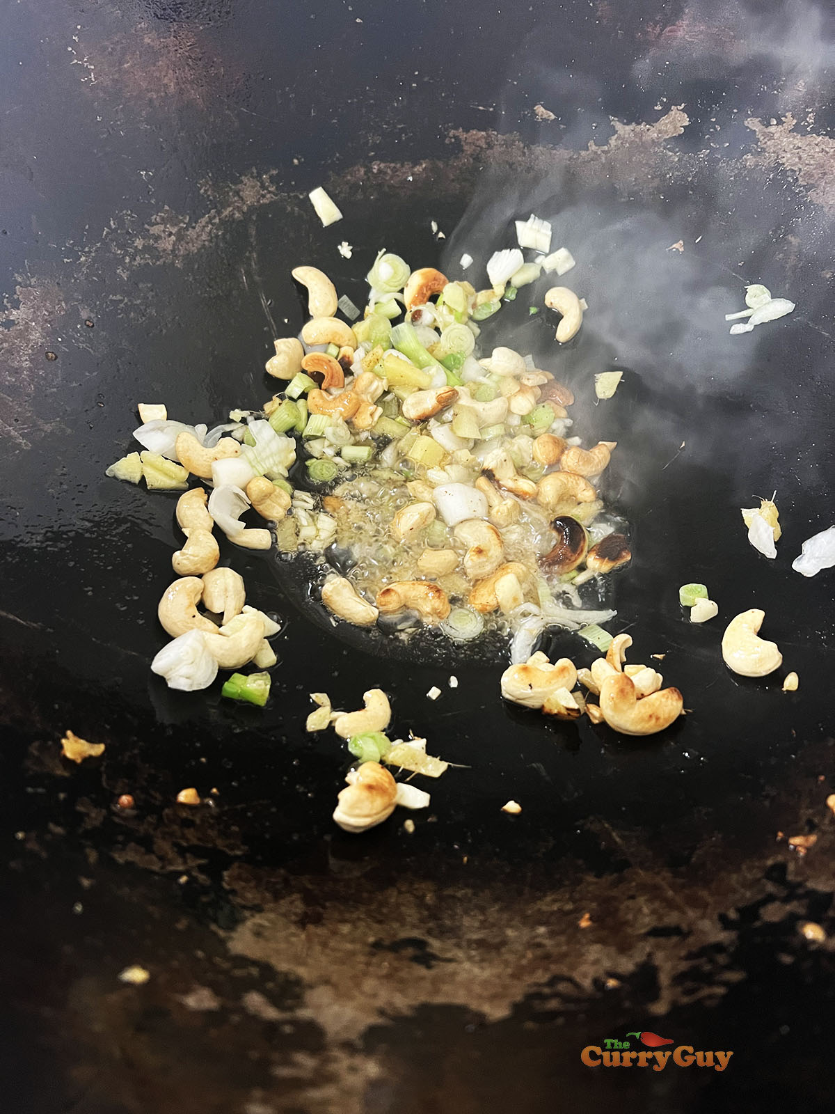 Adding the garlic, ginger and spring onions (scallions).