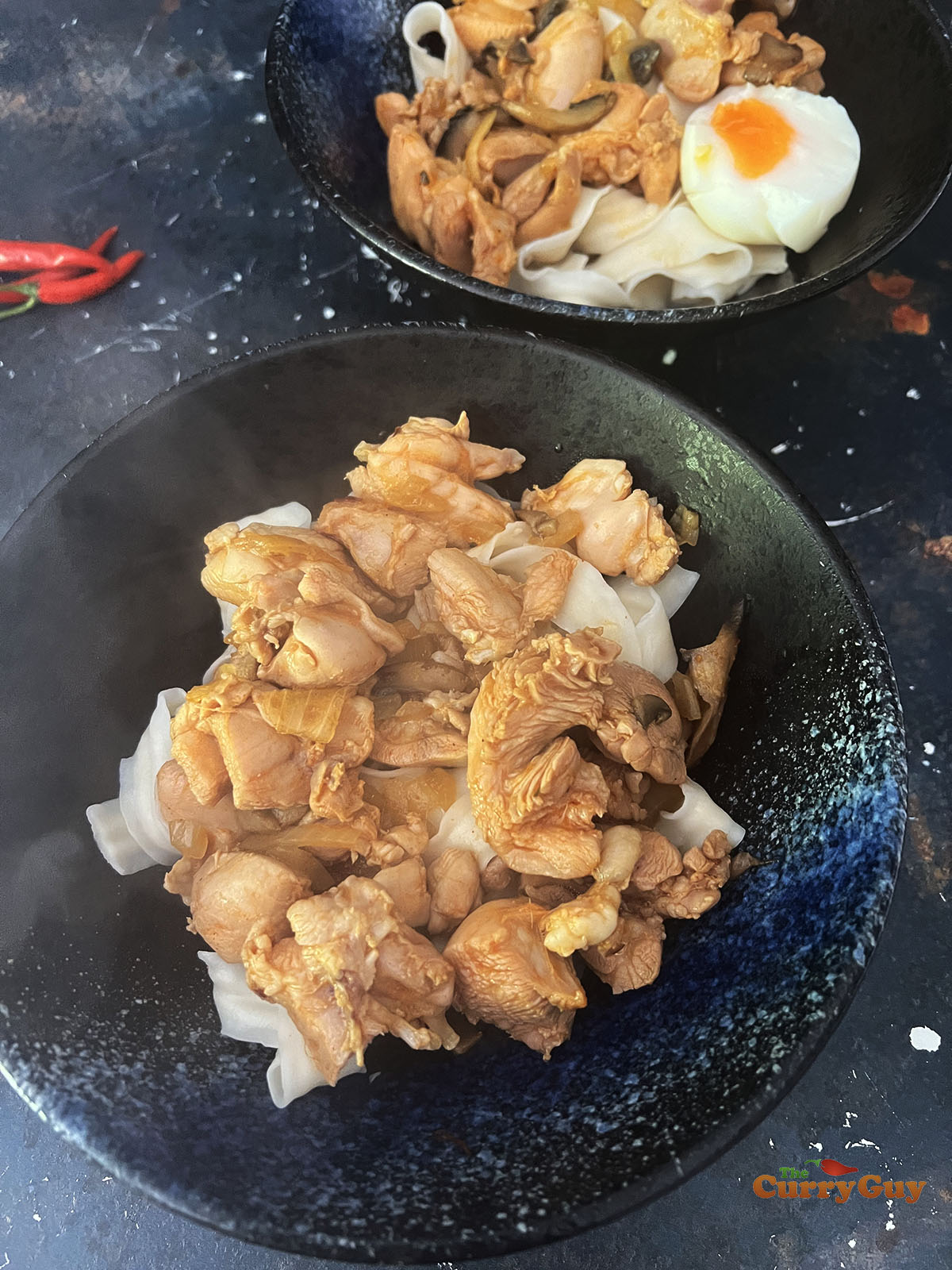 Cooked chicken on top of ramen noodles.