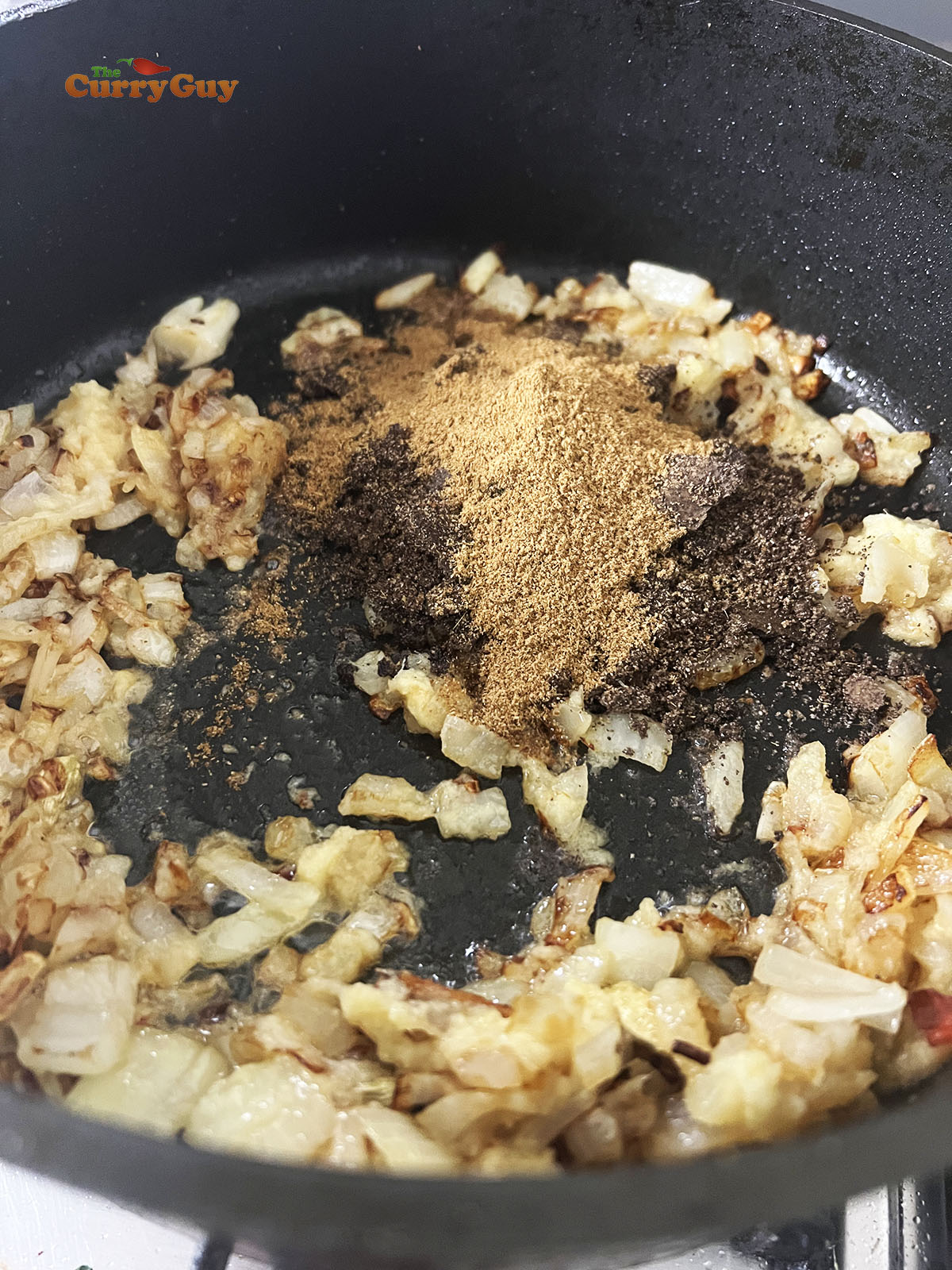 Frying the onions, garlic and ginger and adding the ground poppy seed paste and spice.